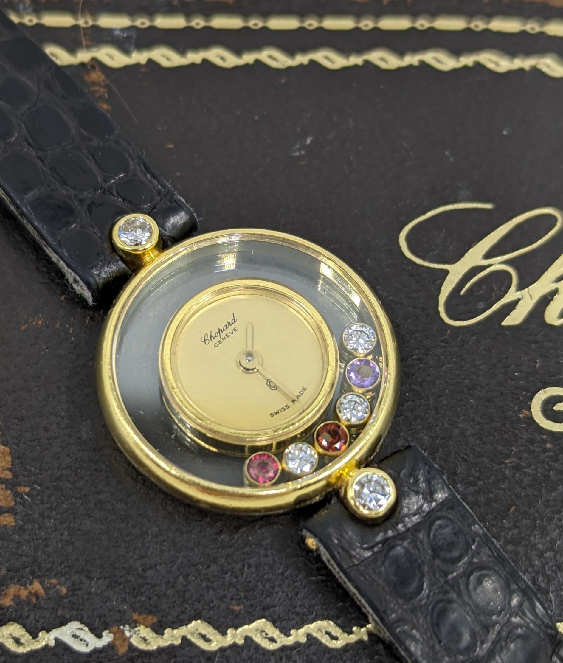A fine and rare Chopard 18K solid yellow gold “HAPPY DIAMONDS” (ref. 20.4069) quartz watch with 8 multi-colored gems and diamonds (6 floating, estimated total diamond weight 0.24ct), original gold plaque Chopard buckle.

Comes with original Chopard