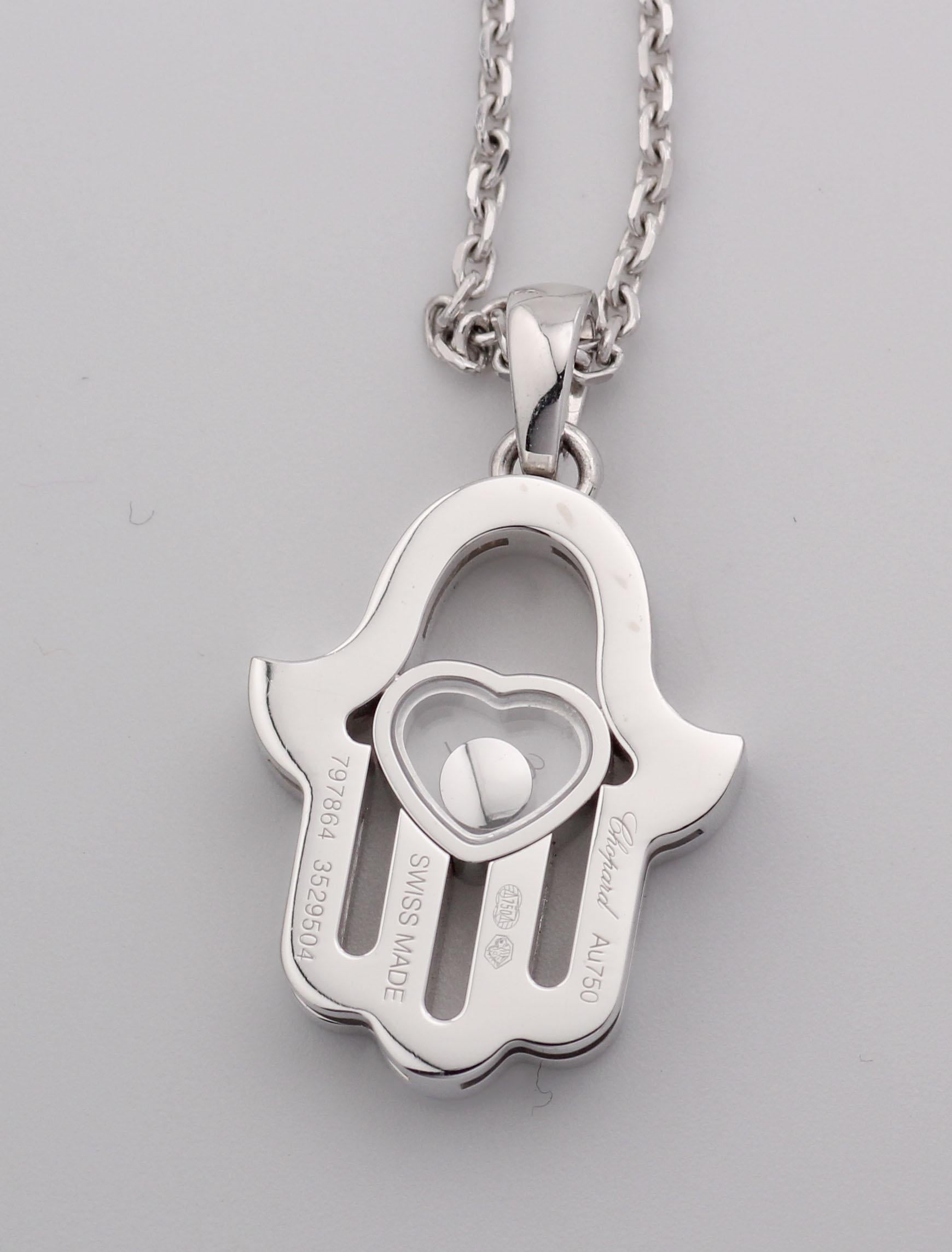 Simbolo di protezione e gioia, la collana con ciondolo a forma di mano Chopard Happy Diamond Hamsa unisce il significato spirituale all'eleganza giocosa tipica della Maison. Realizzato in oro bianco 18 carati, il ciondolo assume la forma della mano