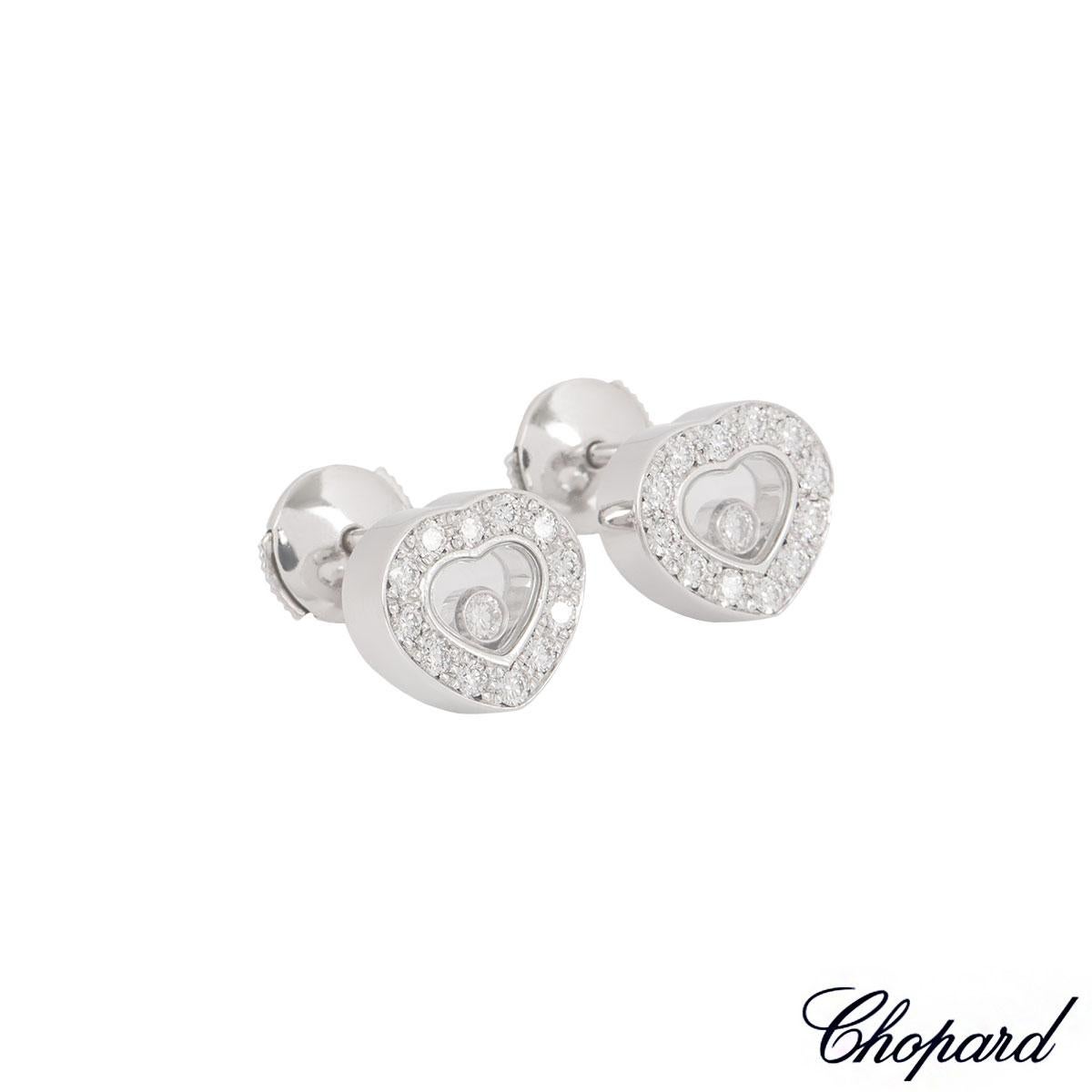 A pair of 18k white gold diamond earrings from the Chopard Happy Diamonds collection. The heart shape earrings have 24 pave set round brilliant cut diamond around the outer edges with a weight of 0.41ct with 1 single floating round brilliant cut