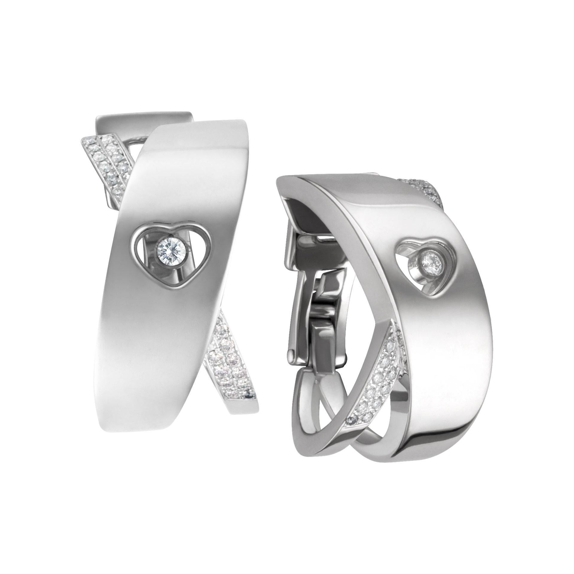 Large Chopard Happy diamond heart hoop earrings with floating diamond in 18k white gold. Hanging length is 0.95