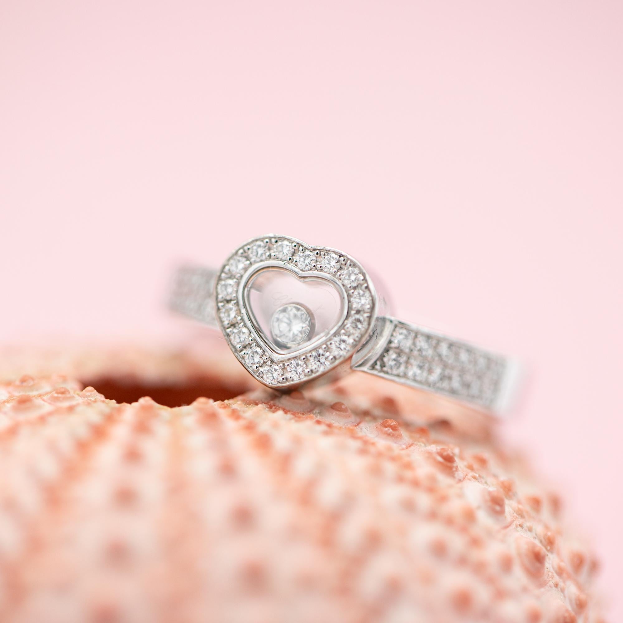 For sale is this wonderful and timeless Chopard ring. This 18 k white gold ring is set with 41 brilliant cut diamonds. This heart shaped ring is from Chopards 'Happy Diamonds' collection. A brilliant cut diamond is set between two crystal glasses,