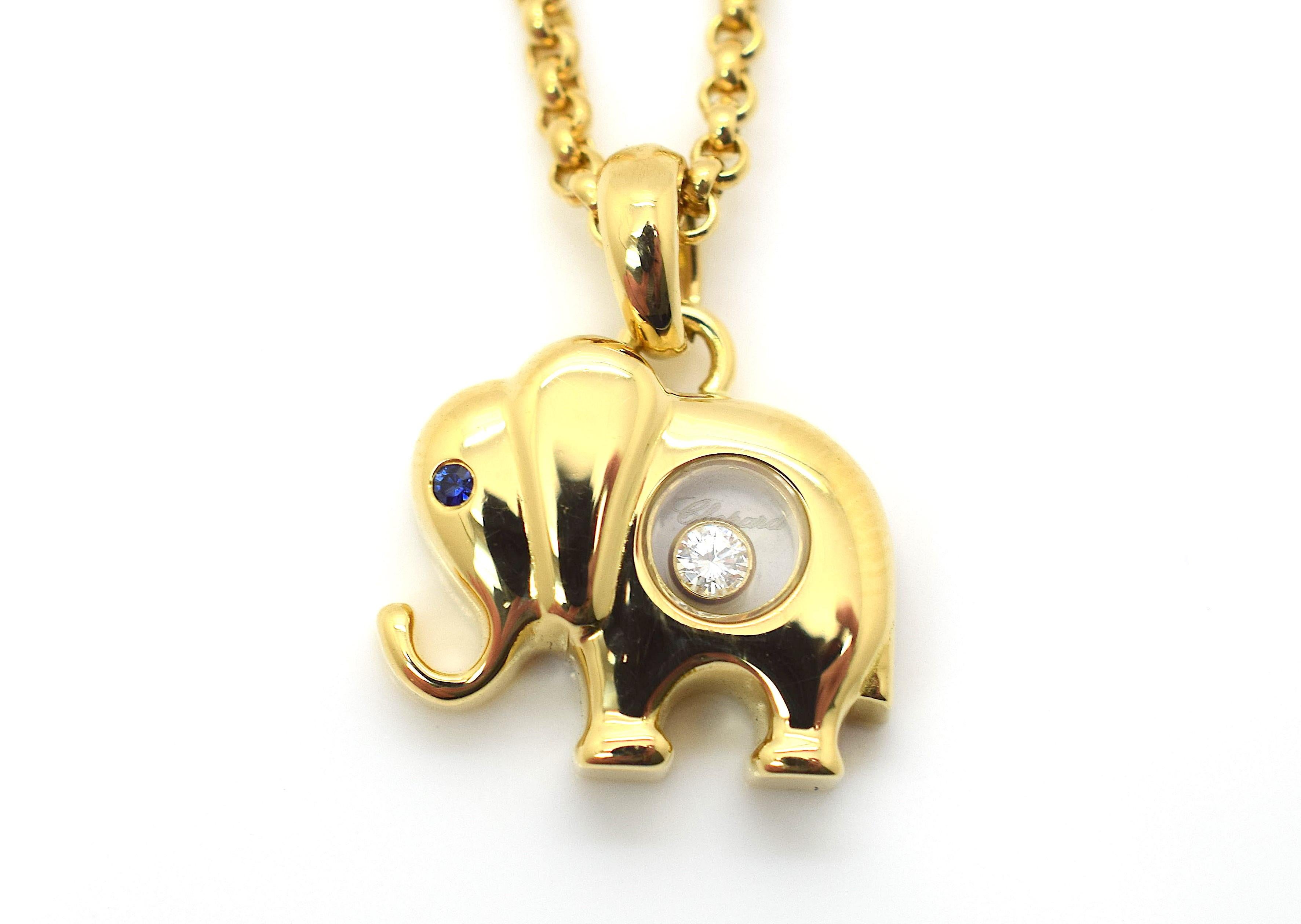 This is a beautiful authentic necklace by Chopard from the Happy Diamond collection, it is crafted from solid 18k yellow gold with a high polished finish. The elephants eye is a small round sapphire and in the center of its body is a round glass
