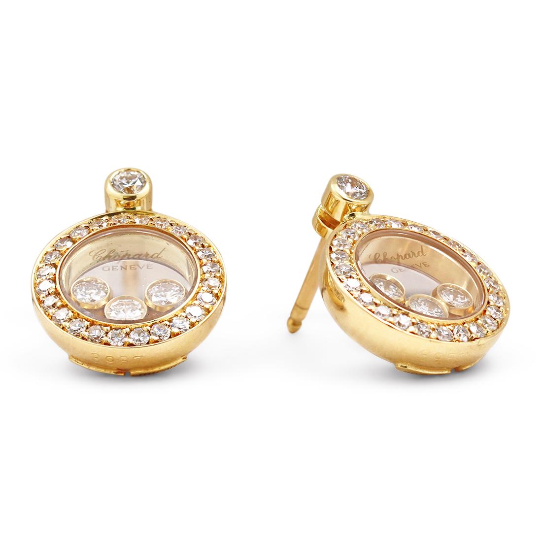 Authentic Chopard 'Happy Diamond' earrings crafted in 18 karat yellow gold. Inspired by the sparkling drops of water in a waterfall, three freely moving diamonds are held between two sapphire crystals on each of these lovely circular earrings.  An