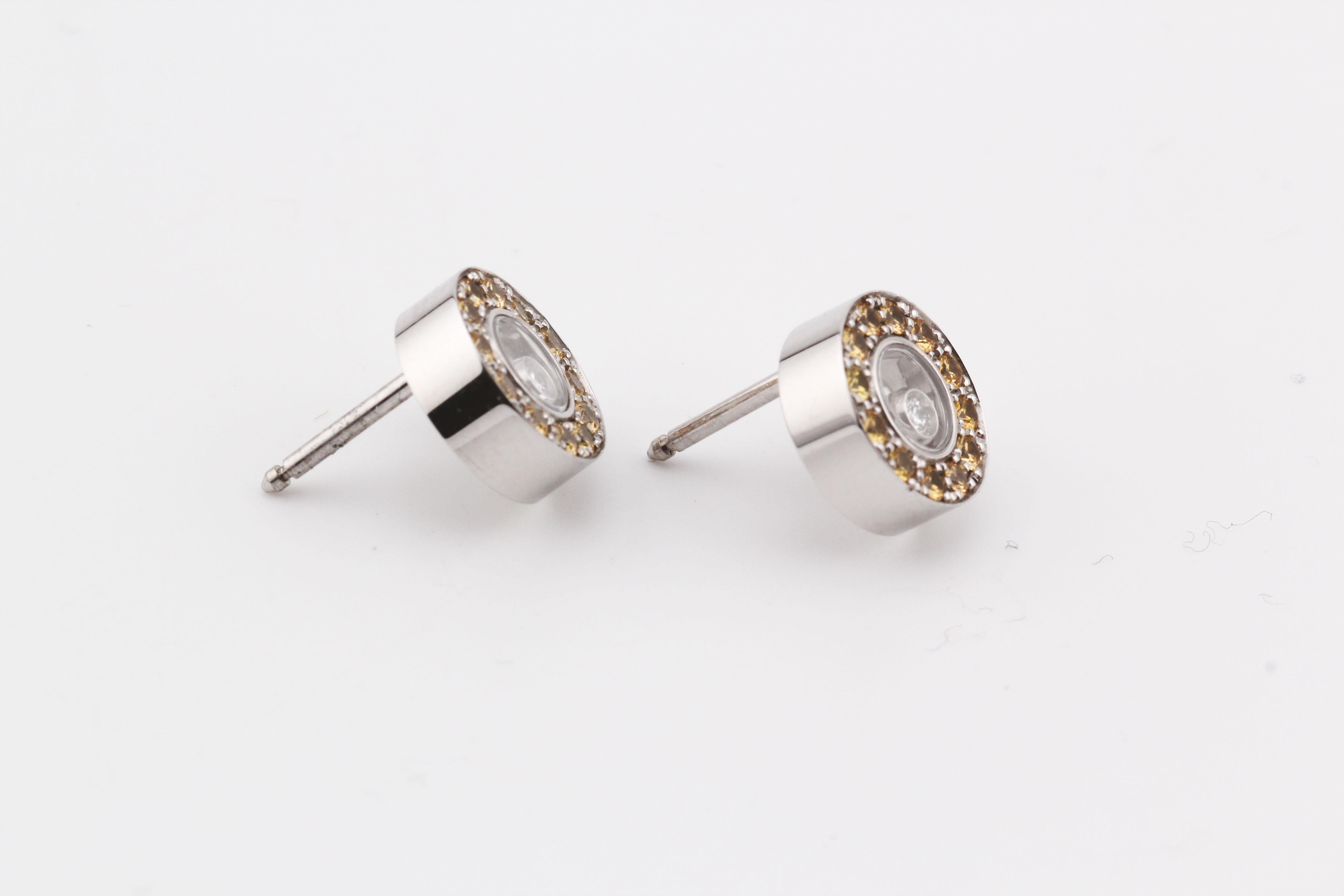 Experience the epitome of luxury and joy with the Chopard Happy Diamond Yellow Sapphire 18K White Gold Stud Earrings – a dazzling testament to exquisite craftsmanship and timeless elegance. Crafted by the renowned Swiss Maison Chopard, these