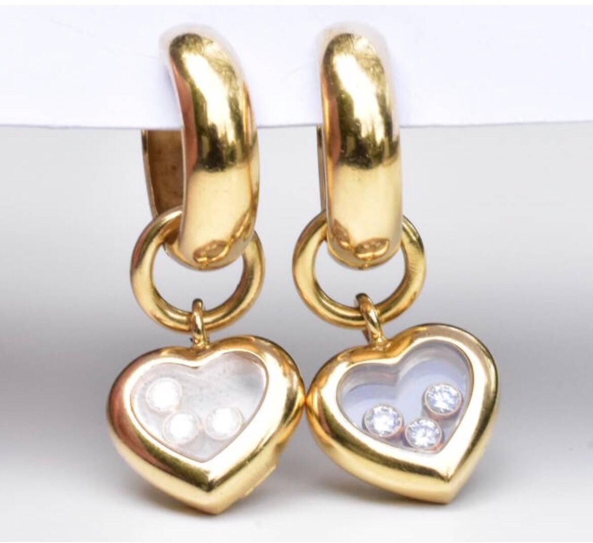 A pair of Chopard Happy Diamond earrings set in 18k. Each earring feature and heart drop pendant with three free moving diamonds set under a sapphire glass with glazed Chopard hallmark.

Hallmarks: Chopard, 750 LUC, glass frosted