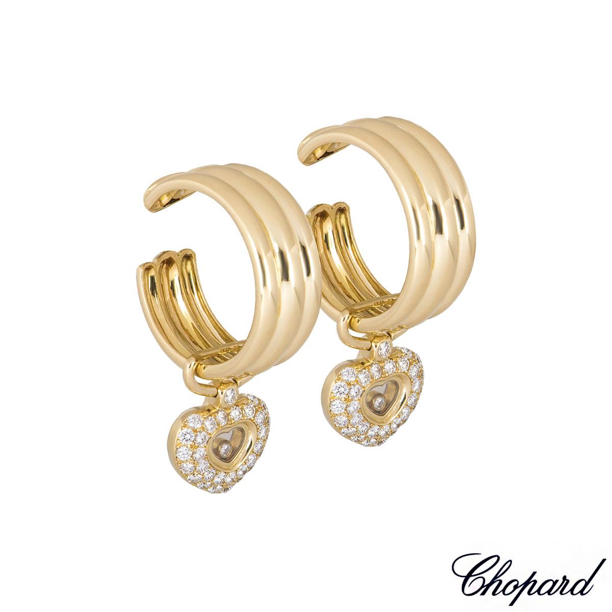 An 18k yellow gold pair of diamond Chopard earrings from the Happy Diamonds collection. The earrings consist of a 3 band plain hoop, with an detachable iconic Happy Diamond heart pave set with round brilliant cut diamonds and a single one through