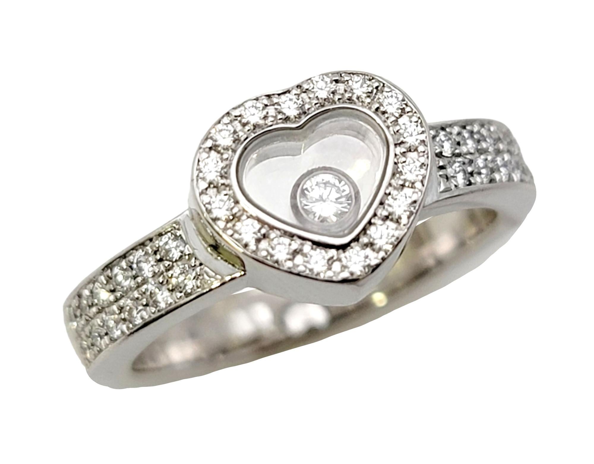 Ring size: 5.5

Dazzling diamond halo ring with a playful floating diamond detail by French designer, Chopard.  Part of the 'Happy Diamonds' collection, this unique heart ring offers sparkle and shine with a unique twist. You will absolutely love