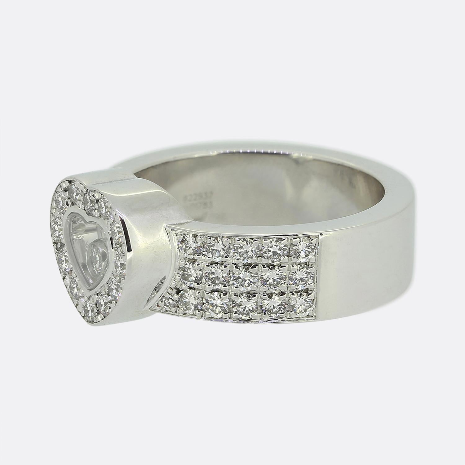 Here we have a dazzling diamond ring from the world renowned French jewellery designer Chopard. This piece has been crafted from 18ct white gold and forms part of their iconic Happy Diamonds collection. The face takes on a love heart design with