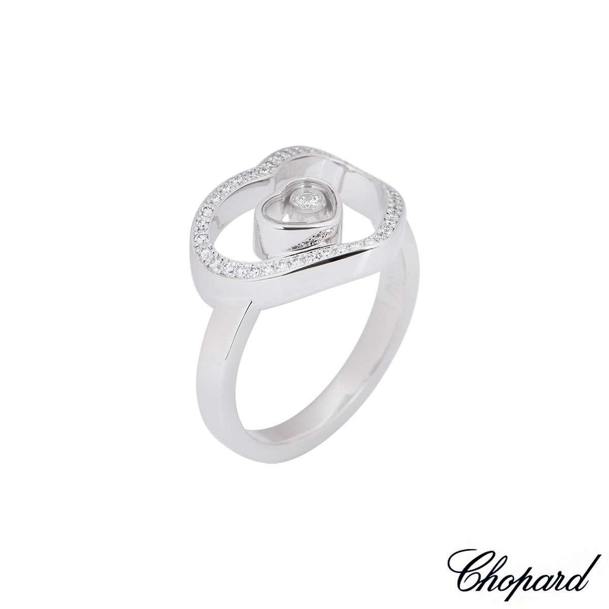 An 18k white gold ring from the Happy Diamonds collection by Chopard. The ring features a large diamond set openwork heart with a smaller heart set within the centre, encasing a single floating diamond. There are a total of 43 round brilliant cut