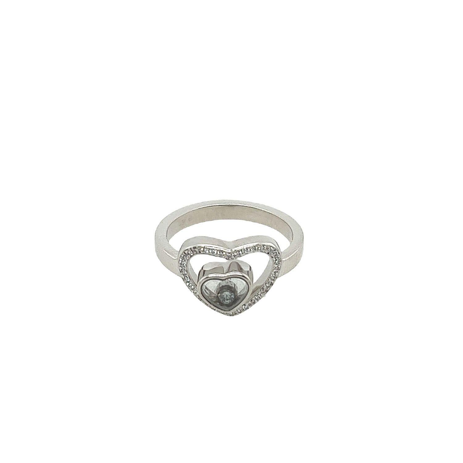 This gorgeous Chopard Happy Diamonds ring set in 18ct white gold featuring small diamonds in the shape of a heart and one playful moving diamond in the center. 
Ref. number: 3207992 
With Original Box
Total Diamond Weight: 0.19ct
Diamond Colour: