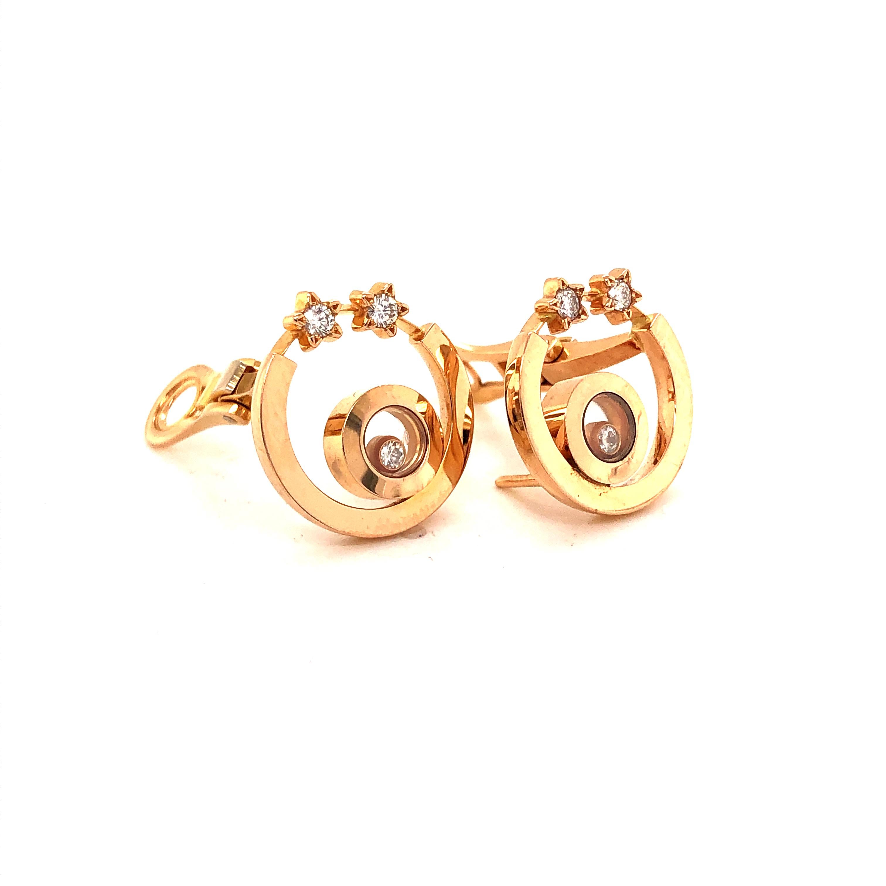 This is an 18k Italian pink gold pair of earrings from Chopard’s ‘Happy Diamonds’ collection. Circular design is seen with diamond encased stars. The center shows Chopard's glass encased circle with 1 floating diamond. These diamonds are all of