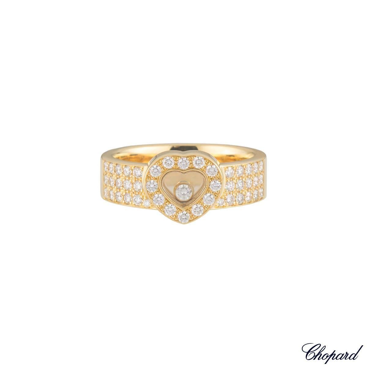 A sparkly 18k yellow gold Chopard diamond ring from the Happy Diamonds collection. The ring comprises of the iconic 2 glass pane motifs in a heart shape with a round brilliant cut diamond floating freely in a rubover setting. The heart motif has