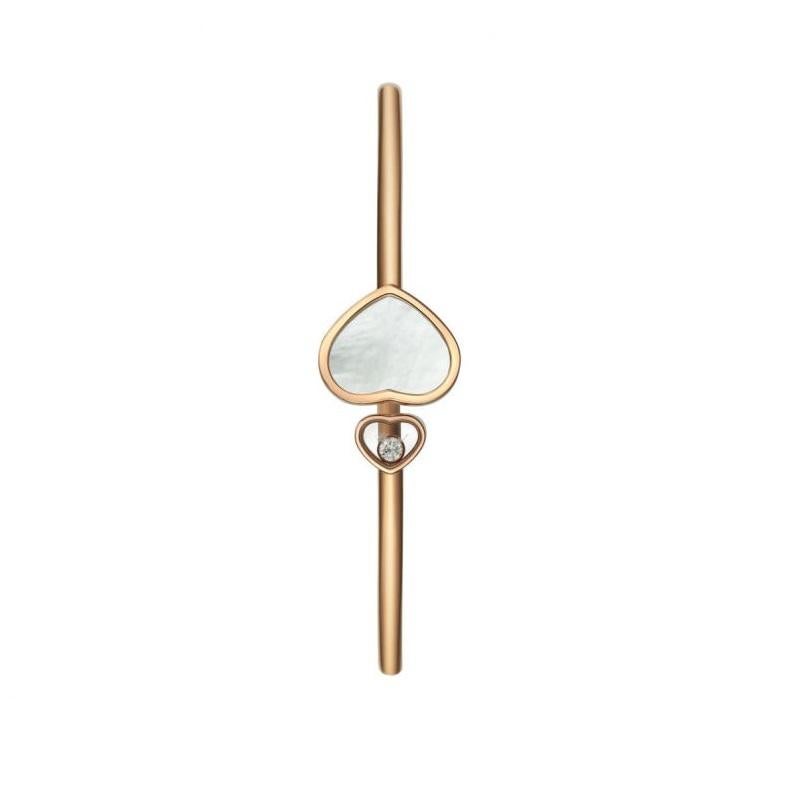 Chopard HAPPY HEARTS BANGLE with 18k rose gold and natural Mother-of-Pearl. This timeless bracelet in 18k rose gold shines with a pair of elegant hearts: a large heart with natural mother-of-pearl at one end and a small heart housing one of