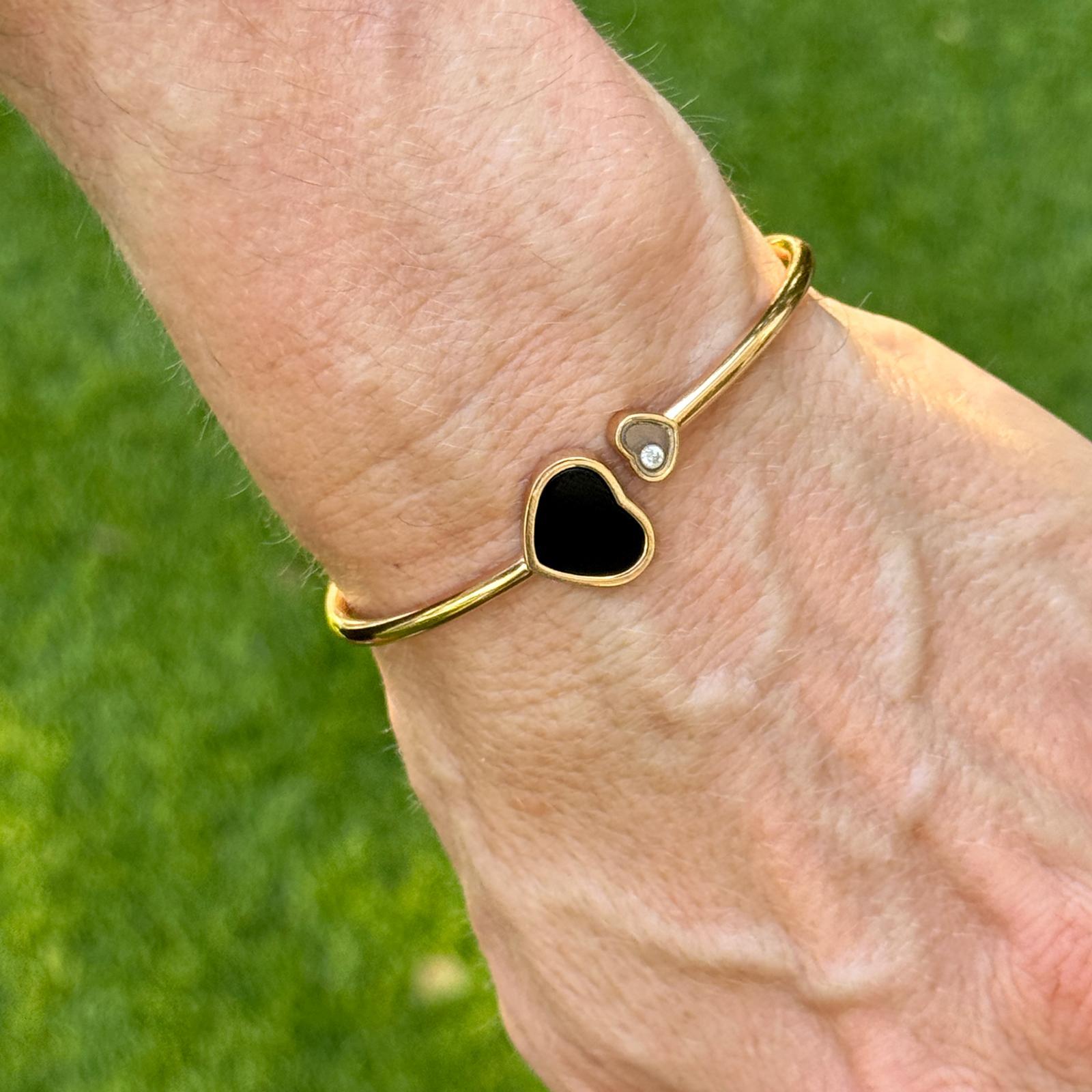 L'élégance ludique rencontre le design intemporel dans ce bracelet Happy Hearts de Chopard, réalisé en or rose 18 carats. L'une des extrémités est ornée d'une pierre d'onyx noir en forme de cœur, tandis que l'autre présente un diamant flottant