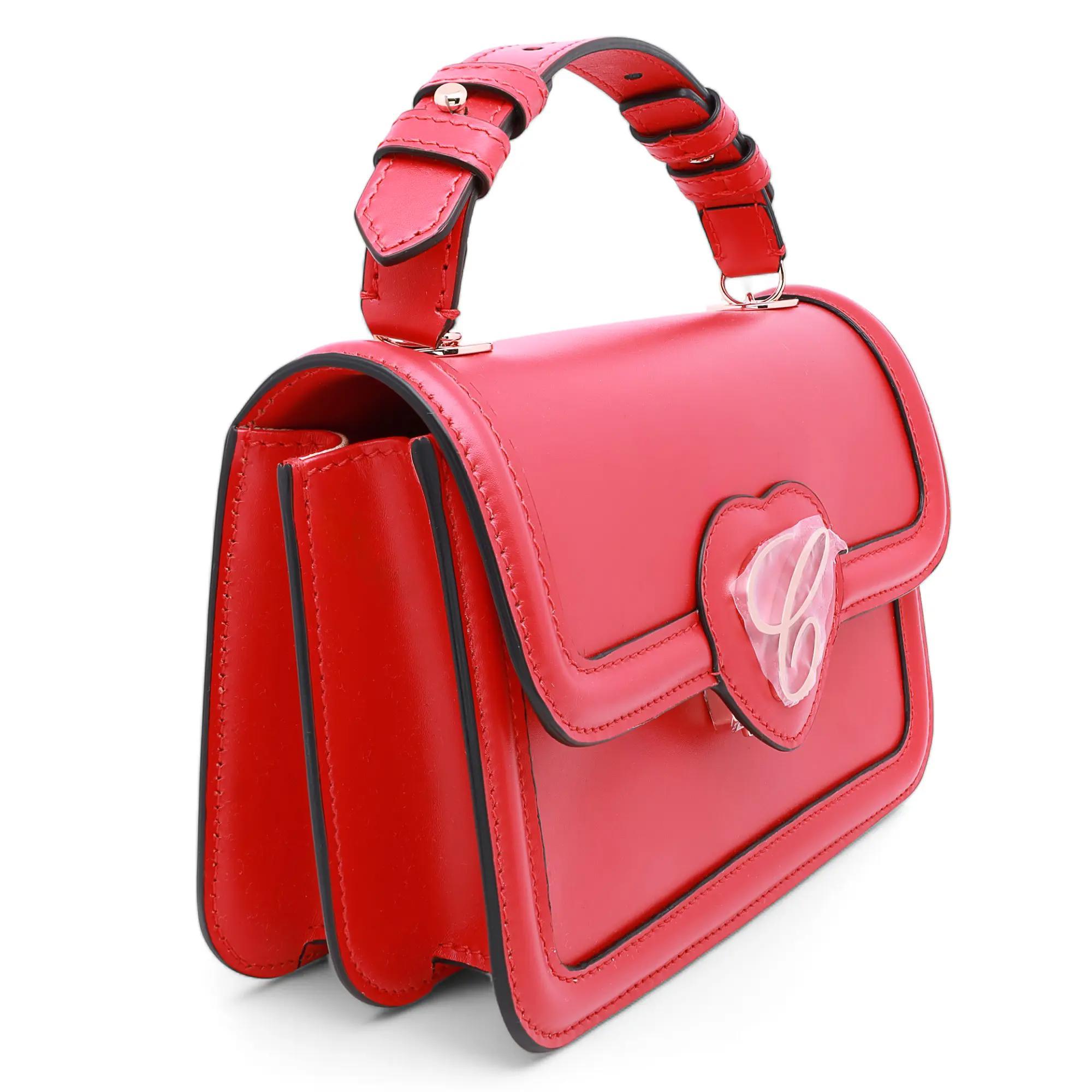 Este pequeño bolso cruzado rojo Happy Hearts, con su diseño delicado pero moderno, realzará a la perfección tanto tu atuendo de trabajo diario como tu sofisticado look de noche. El bolso está confeccionado en fina piel de becerro roja, adornada con