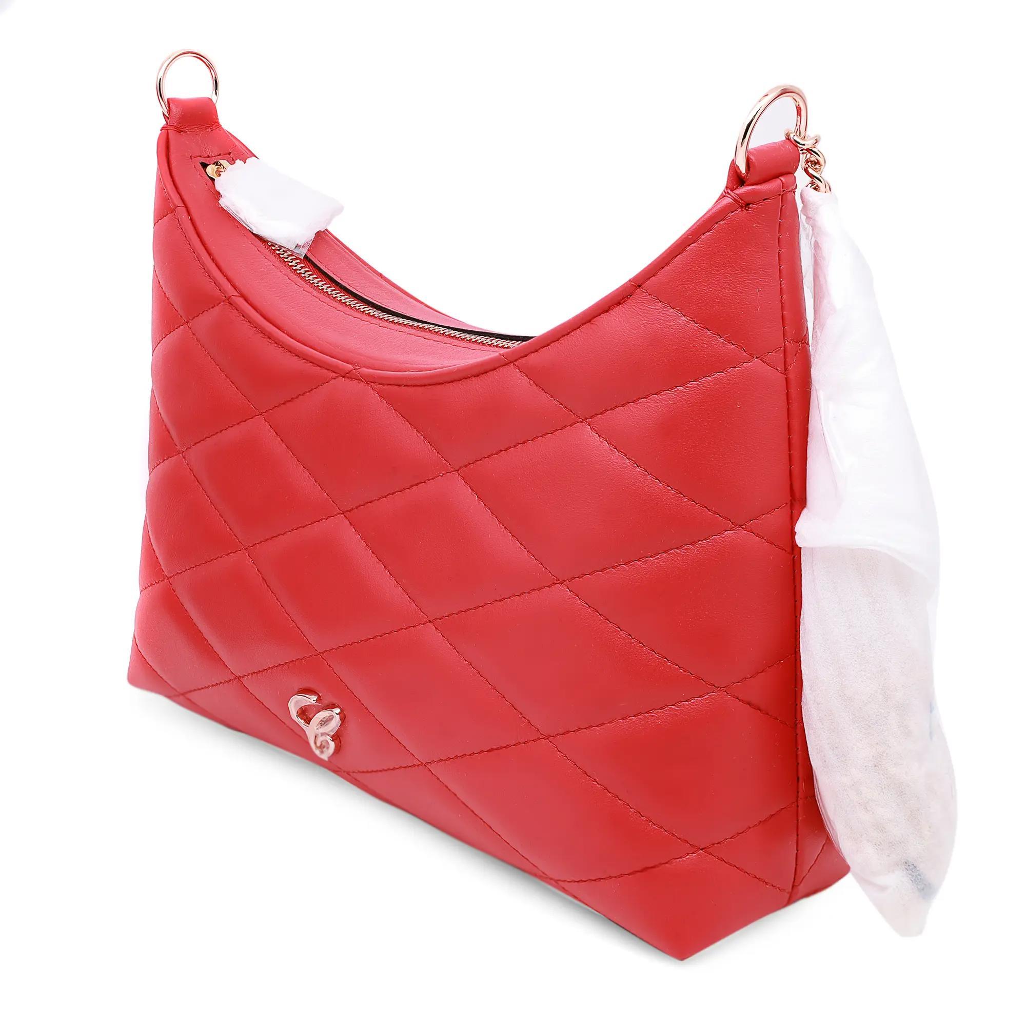 El bolso bandolera de piel acolchada rojo Corazones Felices de Chopard es un accesorio compacto y elegante que presenta un cierre de cremallera superior en forma de corazón para guardarlo con seguridad. Fabricado en piel de becerro roja, luce