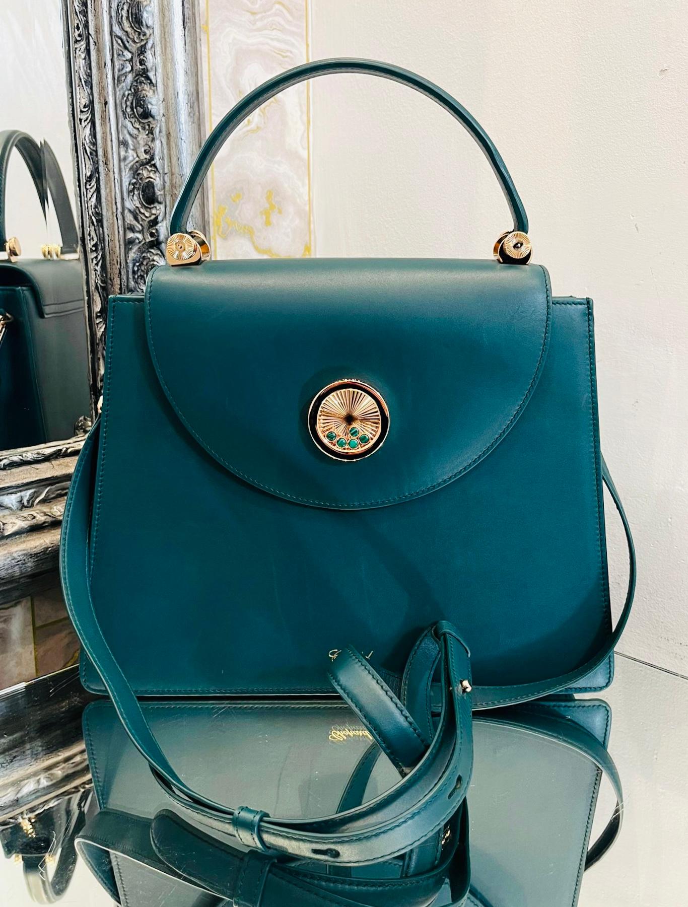 Chopard Happy Lady Leather Bag

Teal green handbag designed with front magnetic flap and single top handle.

Detailed with the brand's signature rose gold, round embellishment with moving emerald cabochons and 'Chopard' engravement.

Featuring