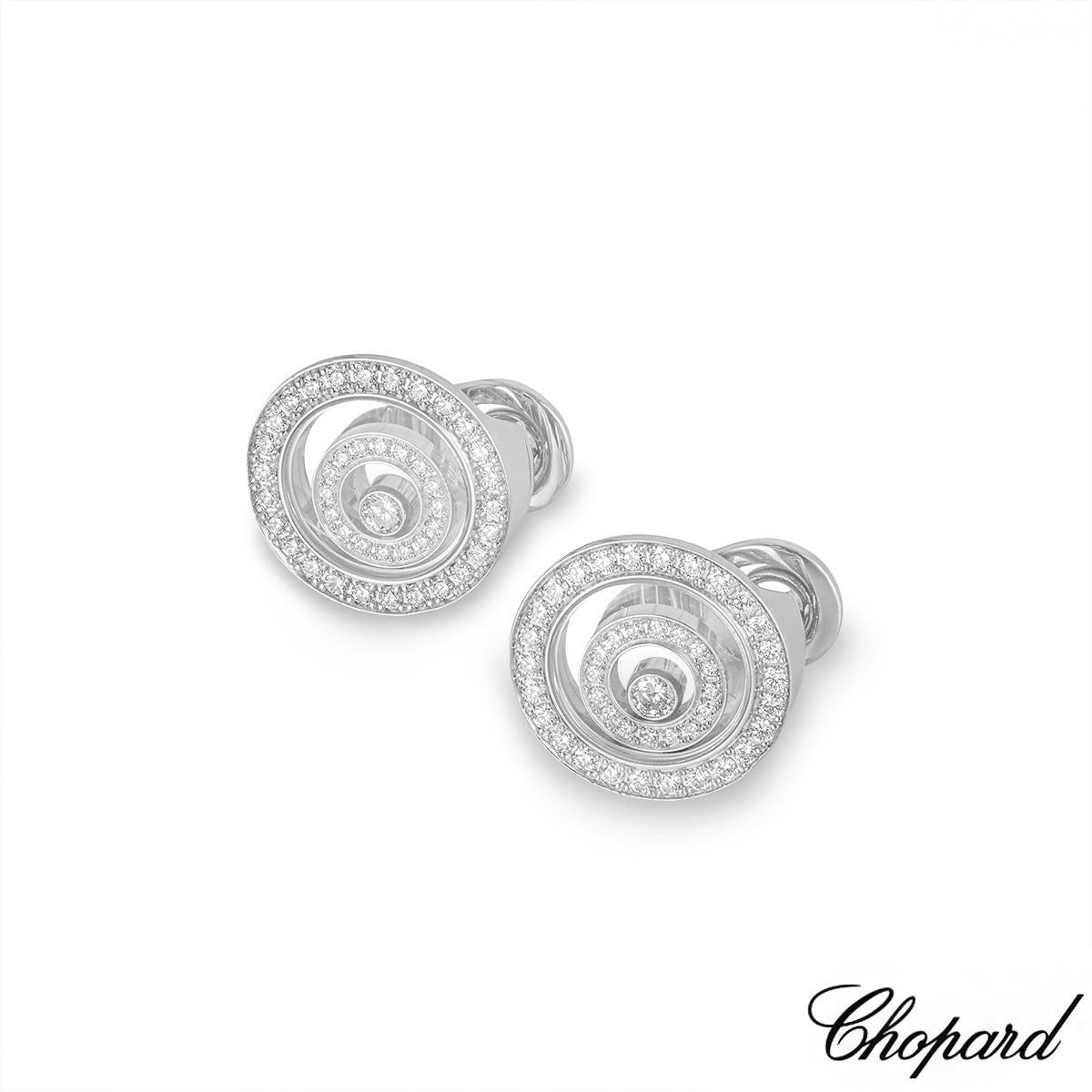 A sparkly pair of 18k white gold diamond earrings by Chopard from the Happy Spirit collection. The earrings are each set with a single floating round brilliant cut diamond inside a freely moving round talisman, pave set with 16 round brilliant cut