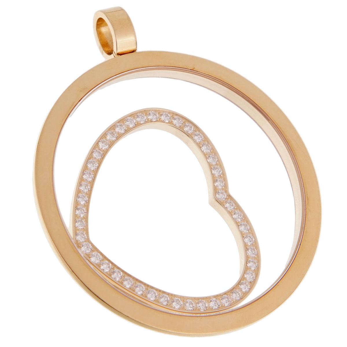 An iconic Chopard Happy Spirit featuring an oversized round pendant with a free floating yellow gold heart adorned with 45 of the finest round brilliant cut diamonds. The pendant measures 1.99