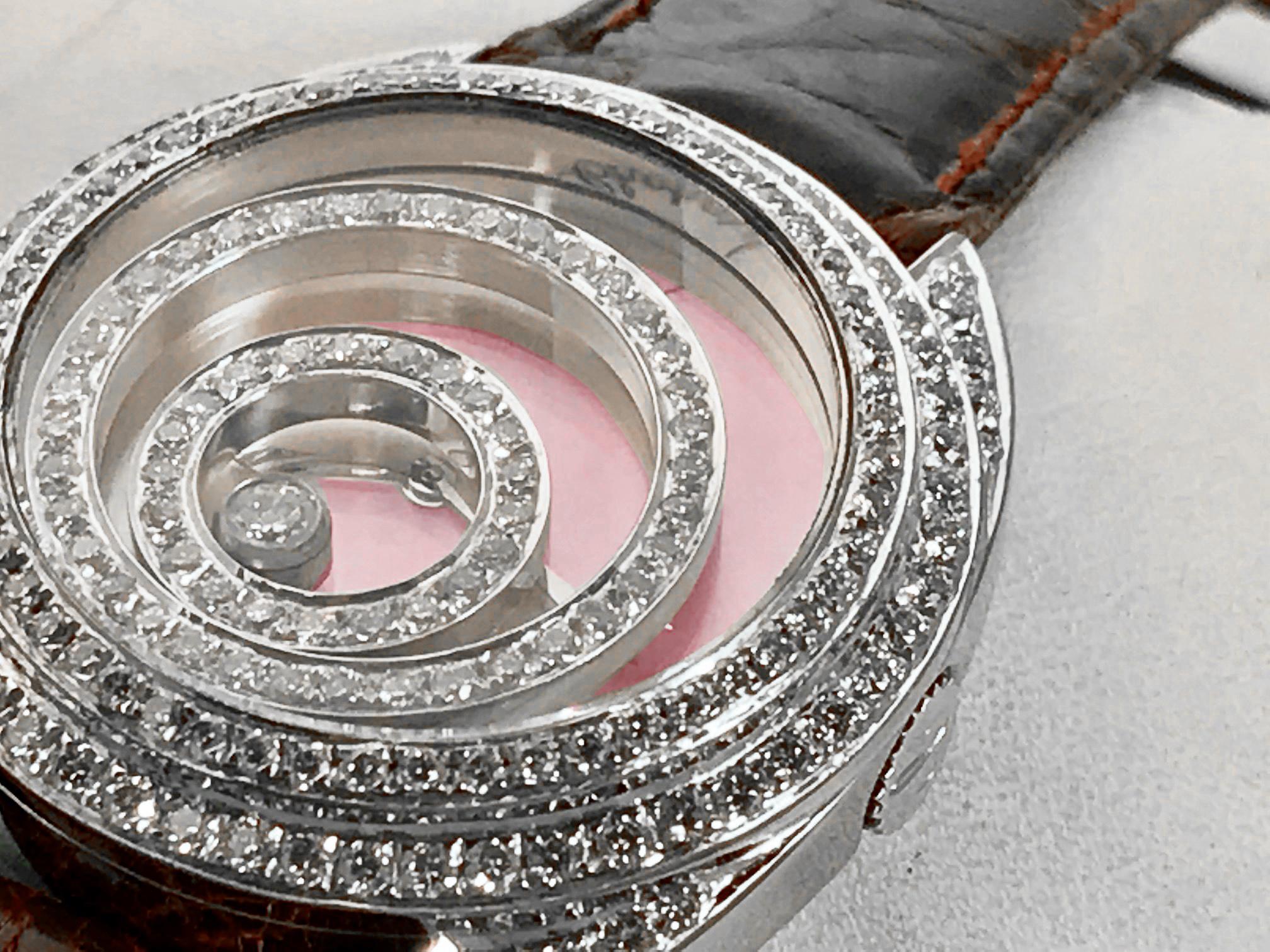 This absolutely gorgeous Chopard Happy Spirit ladies quartz wrist watch is a visual stunner. The dial is a beautiful light pink mother of pearl and is fitted with a custom floating diamond halo set that all articulate and move while your wrist is in
