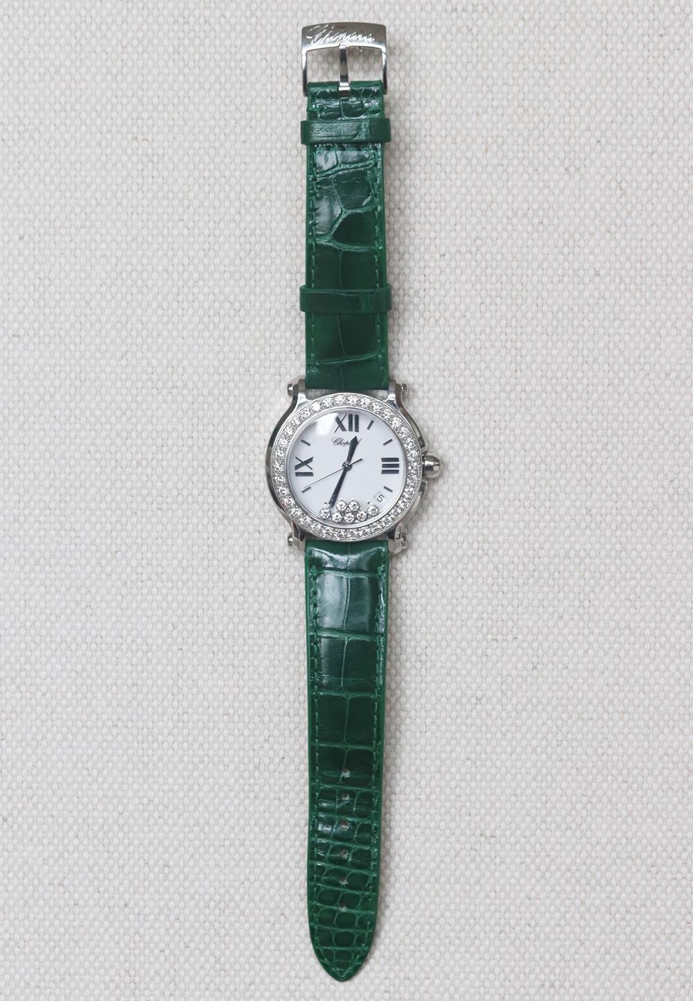 This Chopard ladies watch has 30 mm 18K white gold case adorned with diamond bezel, the white dial with five dancing diamonds and leaf-shaped, white gold-plated hands index richly complements the Roman numeral hour markers. Green alligator leather