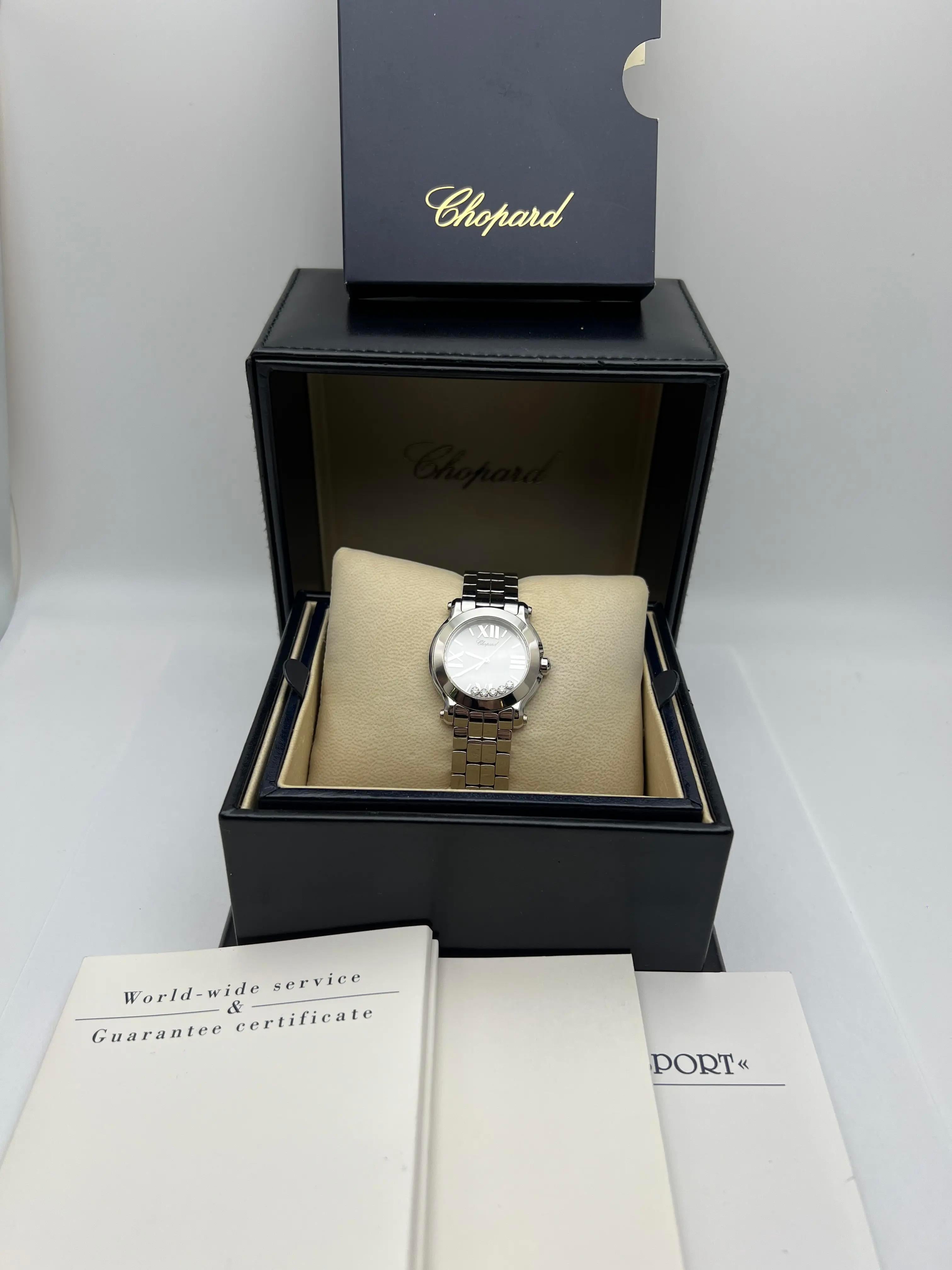 La Happy Sport 278509-3002 de Chopard est dotée d'un boîtier en acier inoxydable de 30 mm et d'une lunette polie, mettant en valeur un cadran blanc épuré avec des chiffres romains et des index bâtons argentés, ainsi que cinq diamants flottants