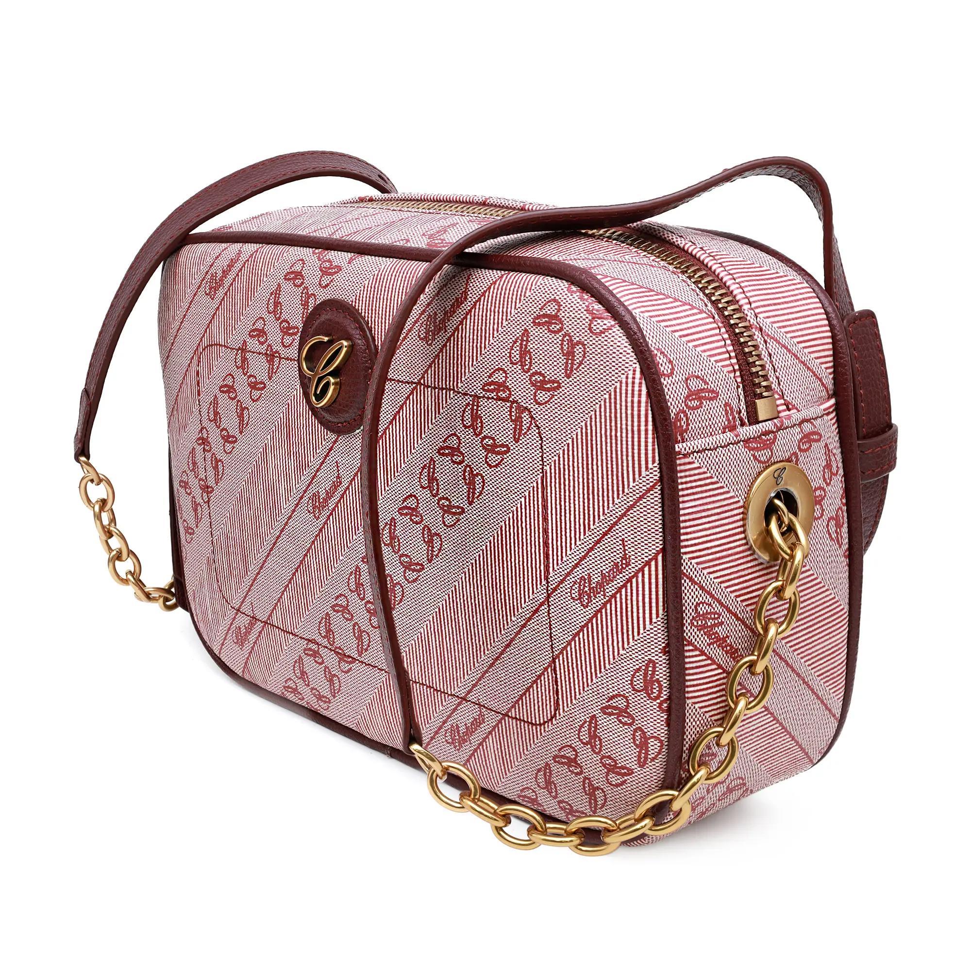 The Chopard Happy Sport Red Canvas Camera Bag 95000-1114 is a compact and stylish accessory featuring a top zipper closure for secure storage. Made from red canvas, it showcases diagonal stripe patterns with the Chopard logo monogram throughout. A