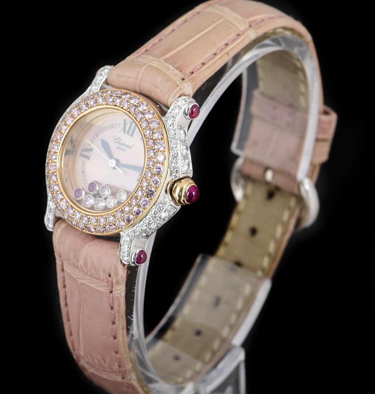 An 18k White Gold Happy Sport Ladies Wristwatch, pink mother of pearl dial with roman numerals III, VI, IX & XII, 2 floating rubover round brilliant cut rubies, 3 floating rubover round brilliant cut pink diamonds & 2 floating rubover round