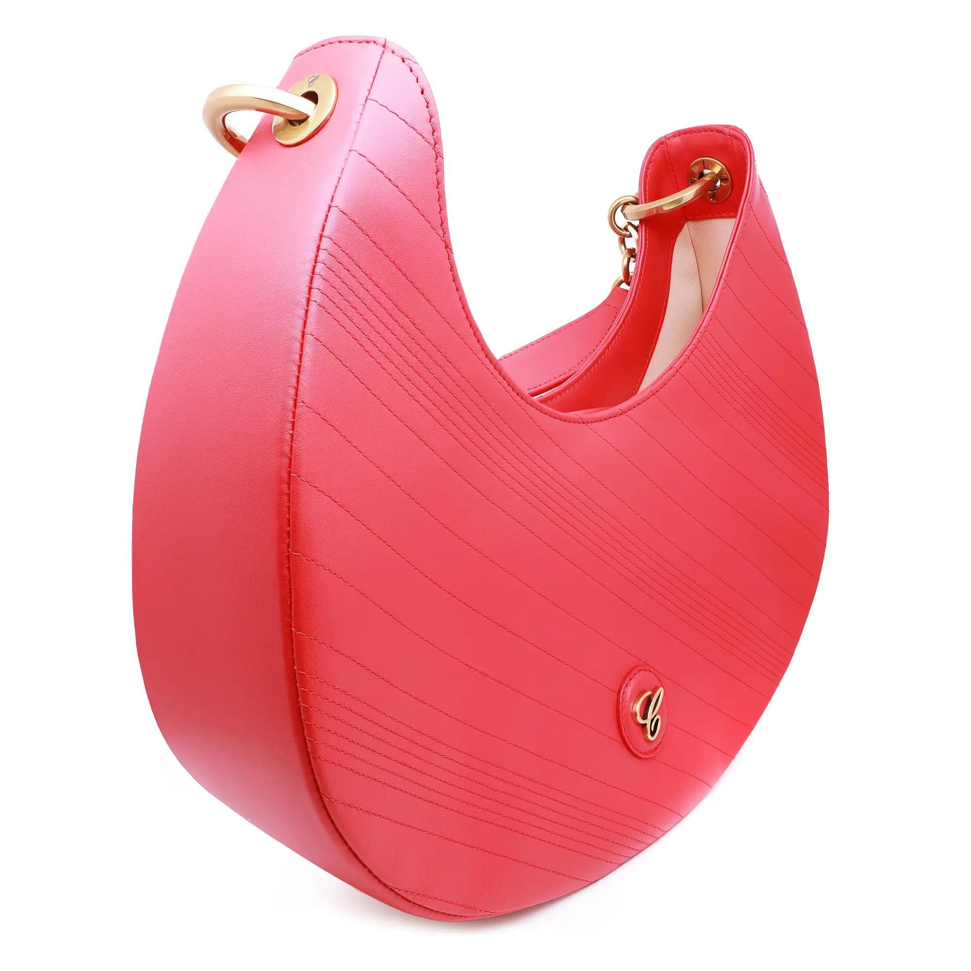 Este es un impresionante bolso hobo de la Colección Happy Sport de Chopard. Este bolso está confeccionado en piel acolchada roja y luce la emblemática 