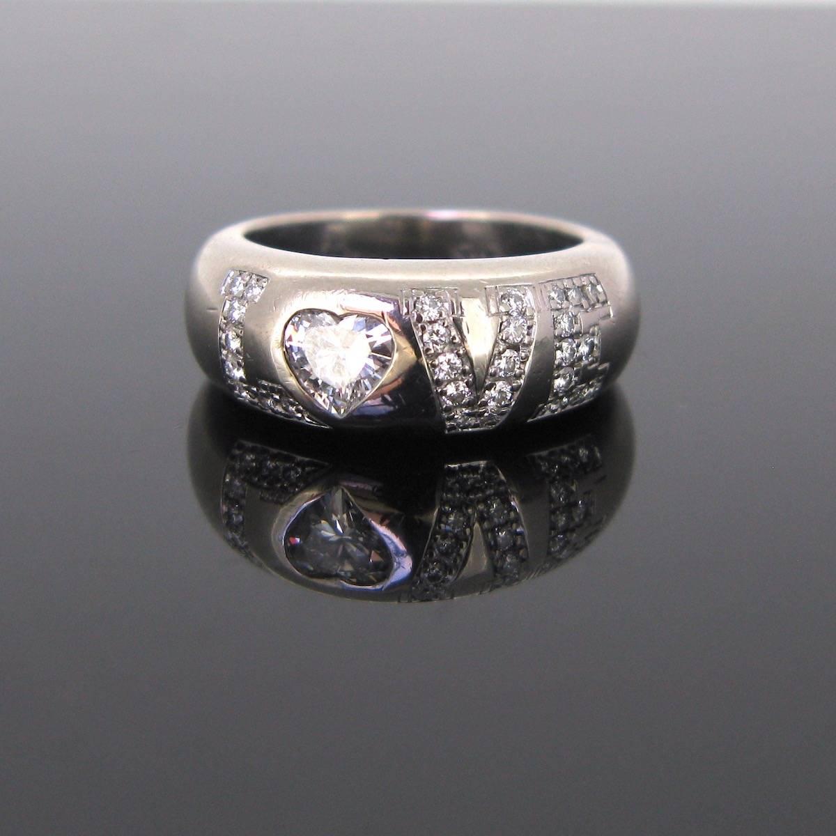 The LOVE Chopard ring. This ring has the word LOVE engraved and set in place with diamonds. The letter O is an approximate 0,40ct heart shape diamond. There is an approximate total carat weight of 0,70ct. The ring band was made in 18kt white gold