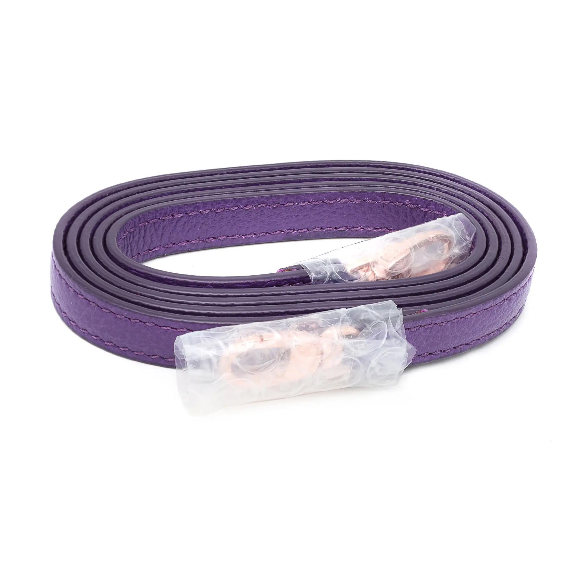 Stylish and vibrant, Chopard Chopardissimo Ice Cube grained leather purple rectangular crossbody bag. It features a front Chopard C logo in the front with a flap top and one slip inner pocket. Comes with a detachable leather strap. Gold tone