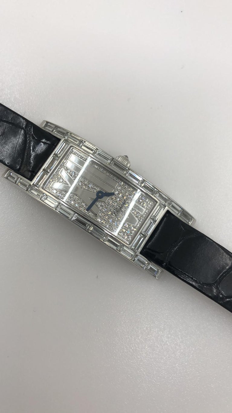 A ladies diamond Chopard watch with a curved rectangular 18k white gold case, set with 28 baguette-cut diamonds and a diamond studded crown, measuring 24 x 40mm

The dial is pave-set in diamond, with blued-steel hands and asymmetrical roman