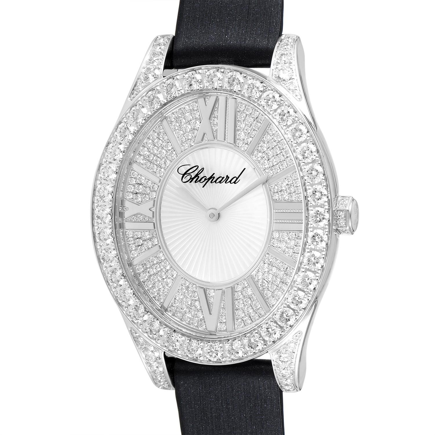The Chopard L'Heure du Diamant watch, reference number 139382-1001, comes with a diamond-set 18K white gold case that is presented on a black satin strap, secured on the wrist with a diamond-set tang buckle. This model is powered by a quartz