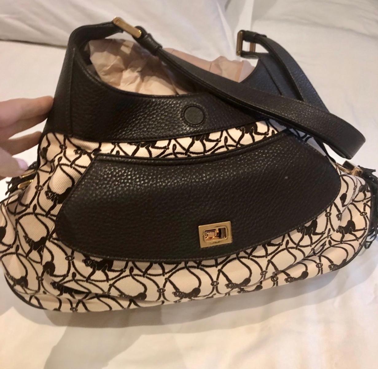 This handbag from Chopard has an earthy yet glamorous feel that is perfect for every day wear. 
Chopard Madrid Brown Cloth & Leather Bag monkey print
Brand new- comes in dust bag (no box)

With dimensions measuring 17 inches long x 4.5 inches wide x