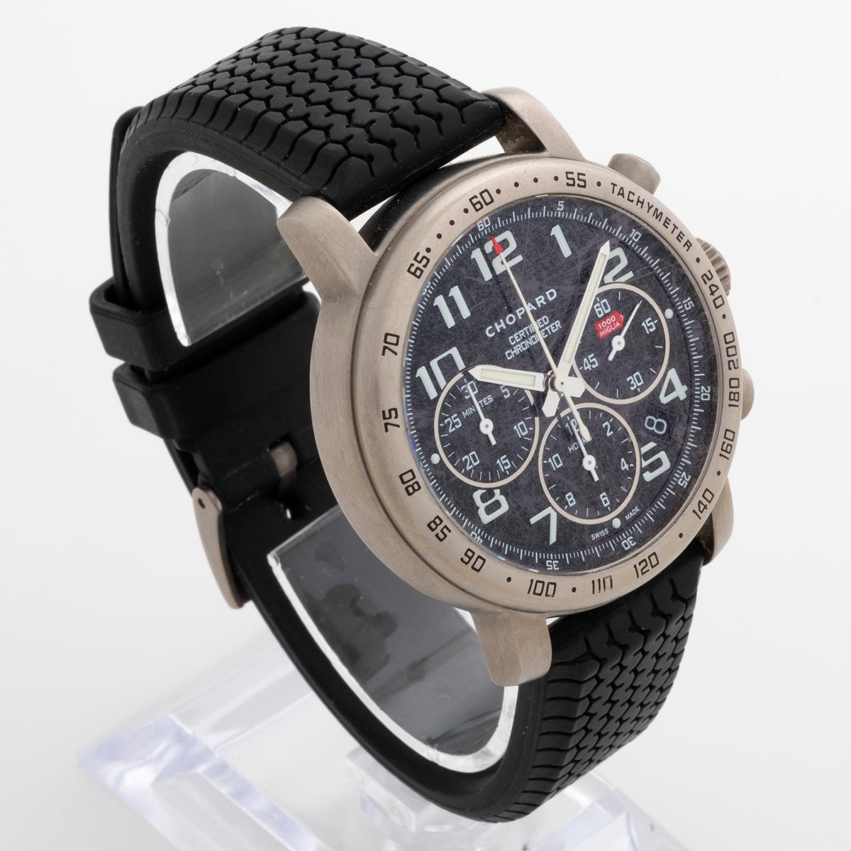 Unsere Chopard Mille Miglia Automatik (Referenz 8915) verfügt über ein 40-mm-Titangehäuse mit Datums- und Chronographenfunktion und einen Saphirglasboden, auf dem das Uhrwerk sichtbar ist. Sie ist mit dem originalen, von Dunlop-Reifen inspirierten