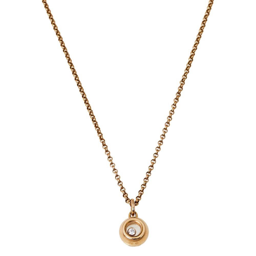 This lovely Chopard necklace is a part of the brand's Happy Diamonds collection. It comes crafted from 18K rose gold and features a slender chain that carries a round pendant. The pendant, which is detailed with a sapphire crystal glass, encloses a