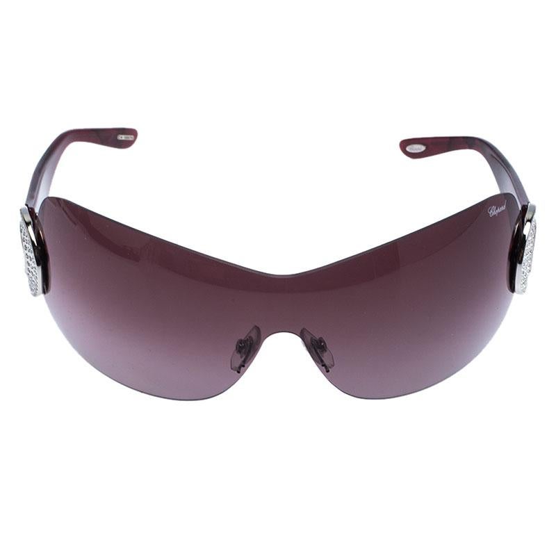 Make those outings stylish while keeping your eyes safe with these Chopard sunglasses. Designed in a shield silhouette with acetate and purple lenses, the pair flaunts the signature crystal embellished metal details as hinges with comfortable nose