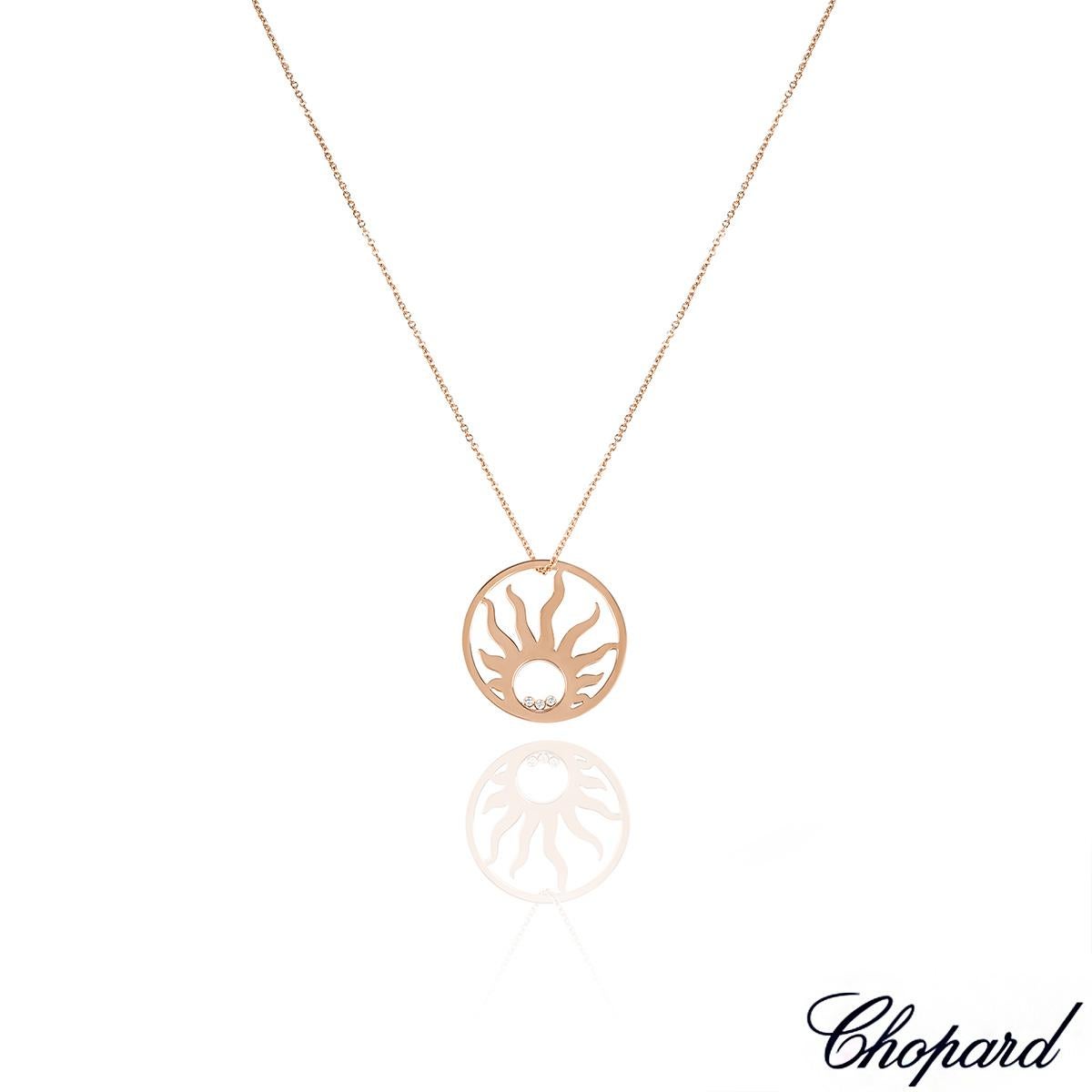 A unique 18k rose gold Chopard diamond necklace from the Happy Diamonds collection. The necklace comprises of a circular disk motif with a sunray in the centre, complemented by 3 floating round brilliant cut diamonds encased behind the iconic signed