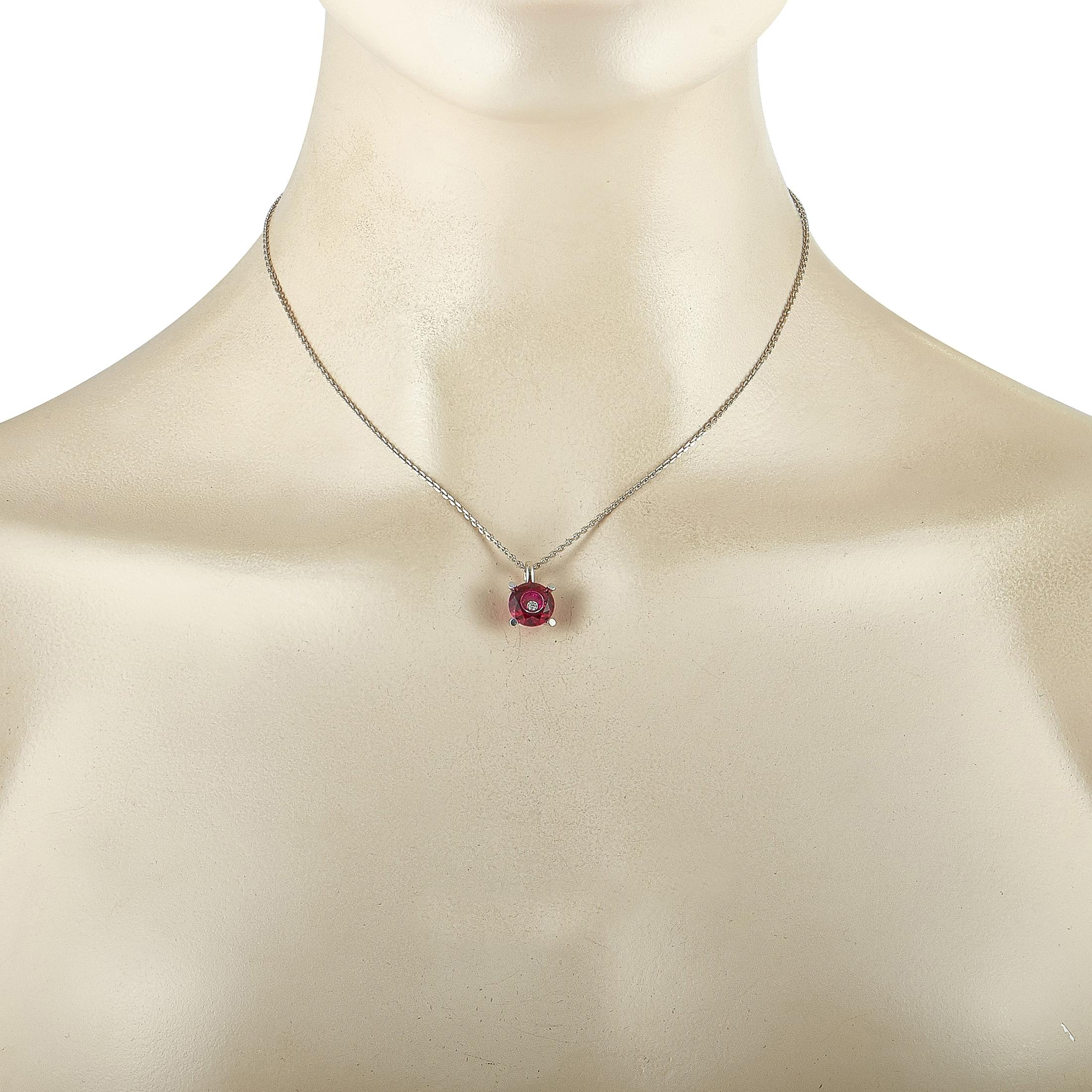 The Chopard “So Happy” necklace is crafted from 18K white gold and embellished with a red stone and a diamond that weighs 0.05 carats. The necklace weighs 6.2 grams and is presented with a 16” chain, onto which a 0.50” by 0.37” pendant is