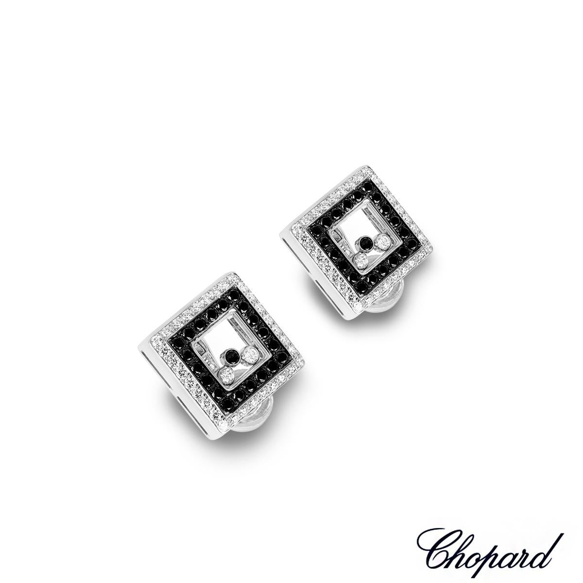 A captivating pair of 18k white gold diamond earrings by Chopard from the Happy Diamonds collection. The square earrings are each set to the outer edge with 32 round brilliant cut white diamonds, set to the inner edge with 20 round cut black