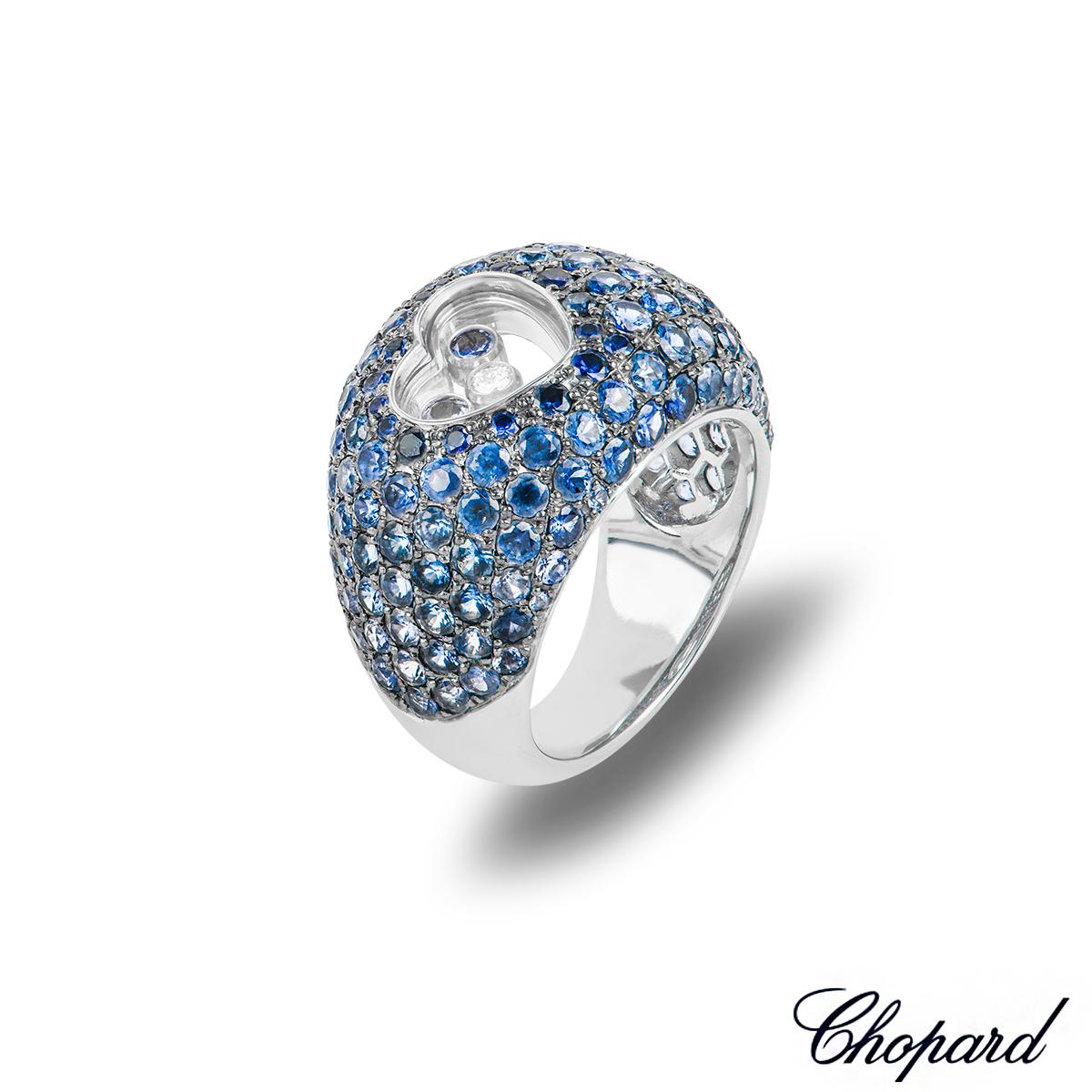 A sensational 18k white gold sapphire and diamond ring by Chopard. The ring features a heart motif set left of centre encasing a single floating round brilliant cut diamond weighing 0.05ct and 2 floating sapphires each weighing 0.05ct. Complementing