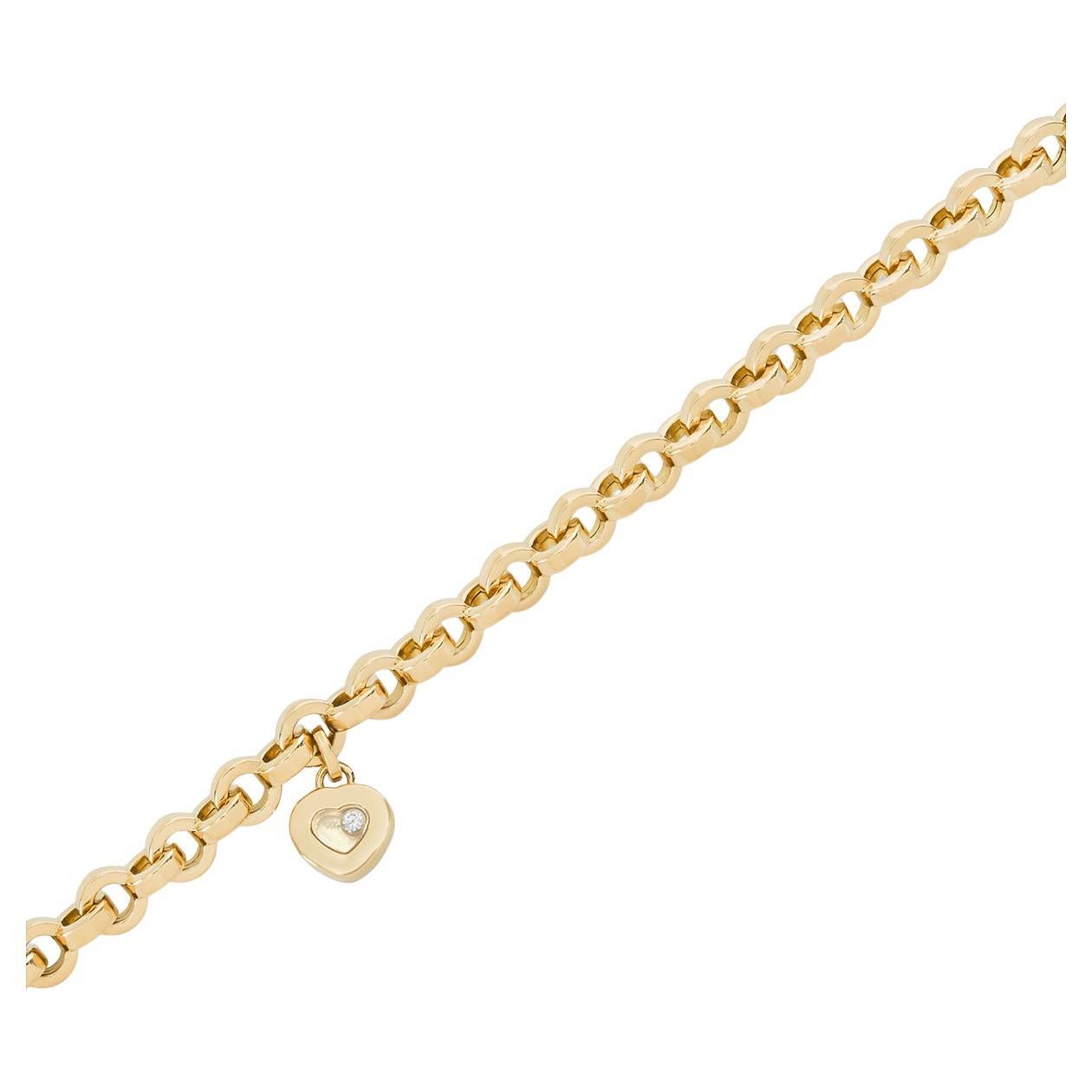 A classy yellow gold bracelet by Chopard from the Happy Diamonds collection. The charm style bracelet features one heart motif charm with a single floating round brilliant cut diamond encased behind the iconic Chopard signed glass. The bracelet
