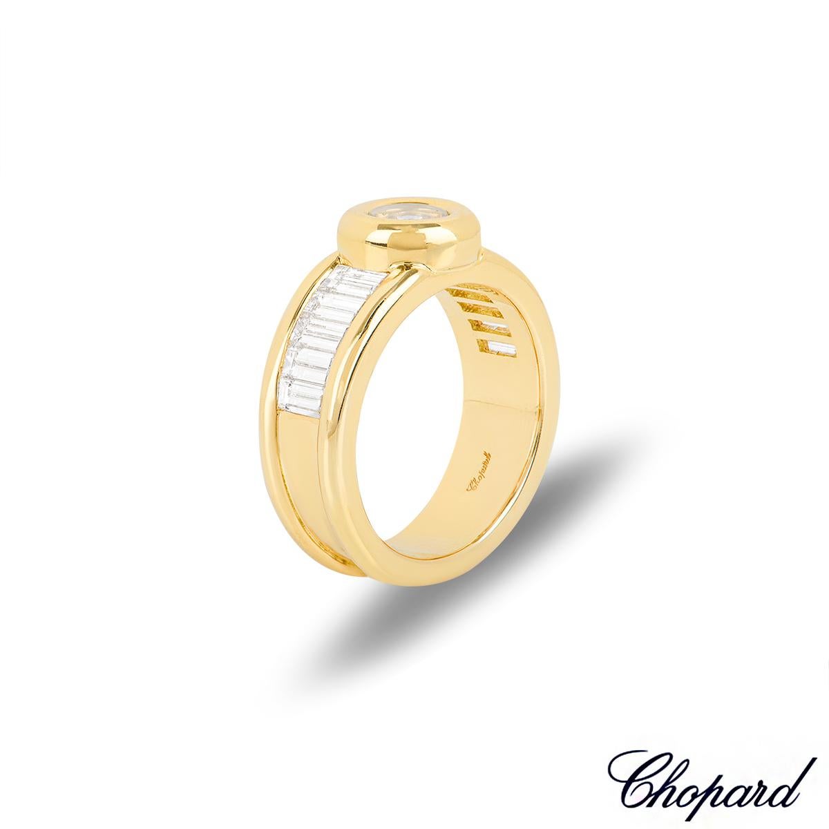 A dazzling 18k yellow gold ring from the Chopard Happy Diamonds collection. The ring is set to the centre with a circular motif, made up of the iconic Chopard signed glass, encasing a 0.10ct single bezel set floating diamond. Complementing the motif