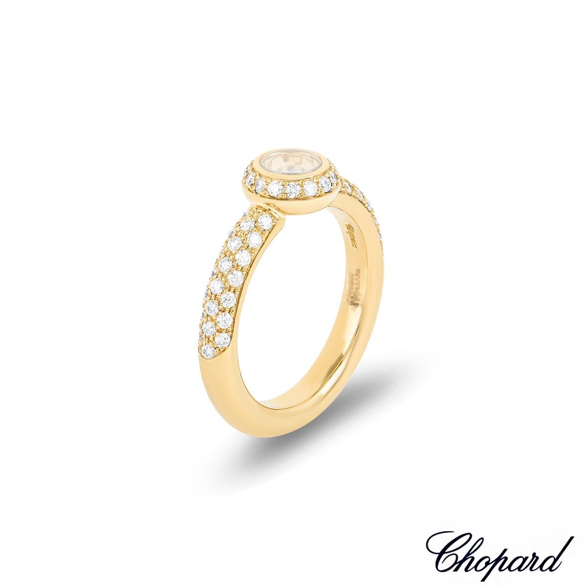 A sparkly 18k yellow gold Happy Diamonds ring by Chopard. The ring features a circular motif set to the centre with a halo of 15 round brilliant cut diamonds with an approximate weight of 0.13ct. In the centre of the circular motif is a single round