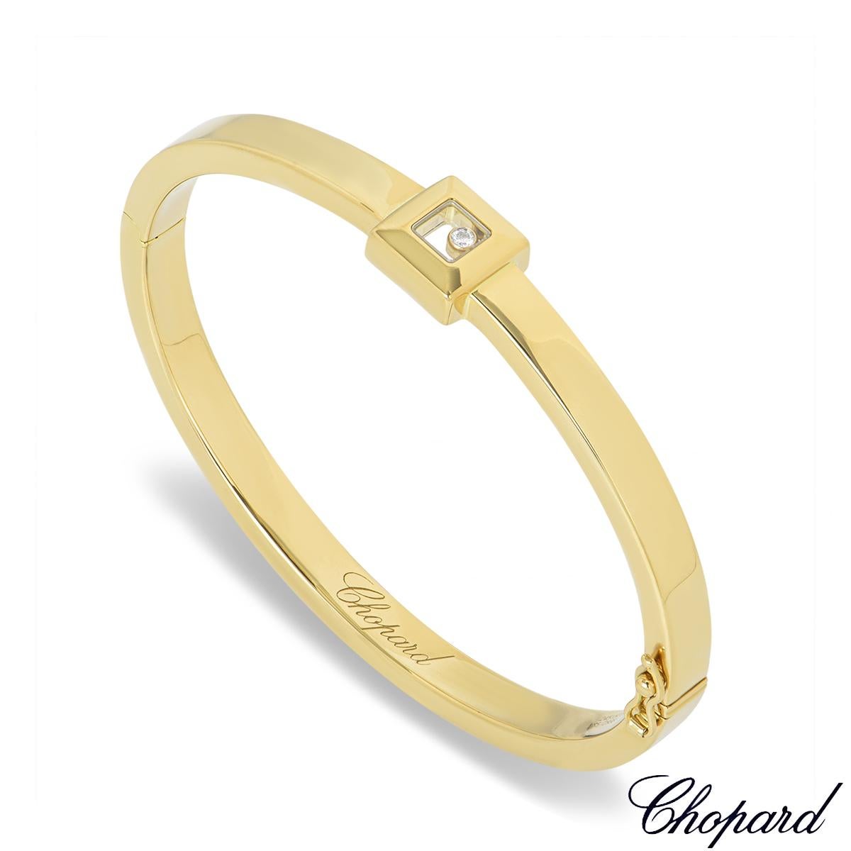 Ein eleganter Chopard-Armreif aus 18 Karat Gelbgold aus der Happy Diamonds Kollektion. Der Armreif besteht aus einem 10 mm großen quadratischen Motiv mit einem einzelnen runden Brillanten, der zwischen zwei ikonischen, von Chopard signierten