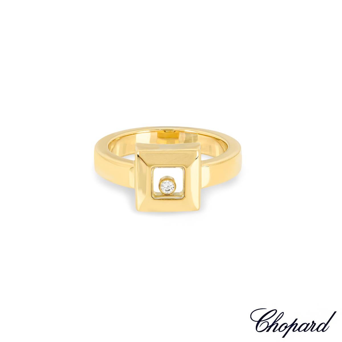 A stylish 18k yellow gold Chopard diamond ring from the Happy Diamonds collection. The ring features a square motif comprising of a floating round brilliant cut diamond set in between two iconic Chopard signed glass panels, with an approximate
