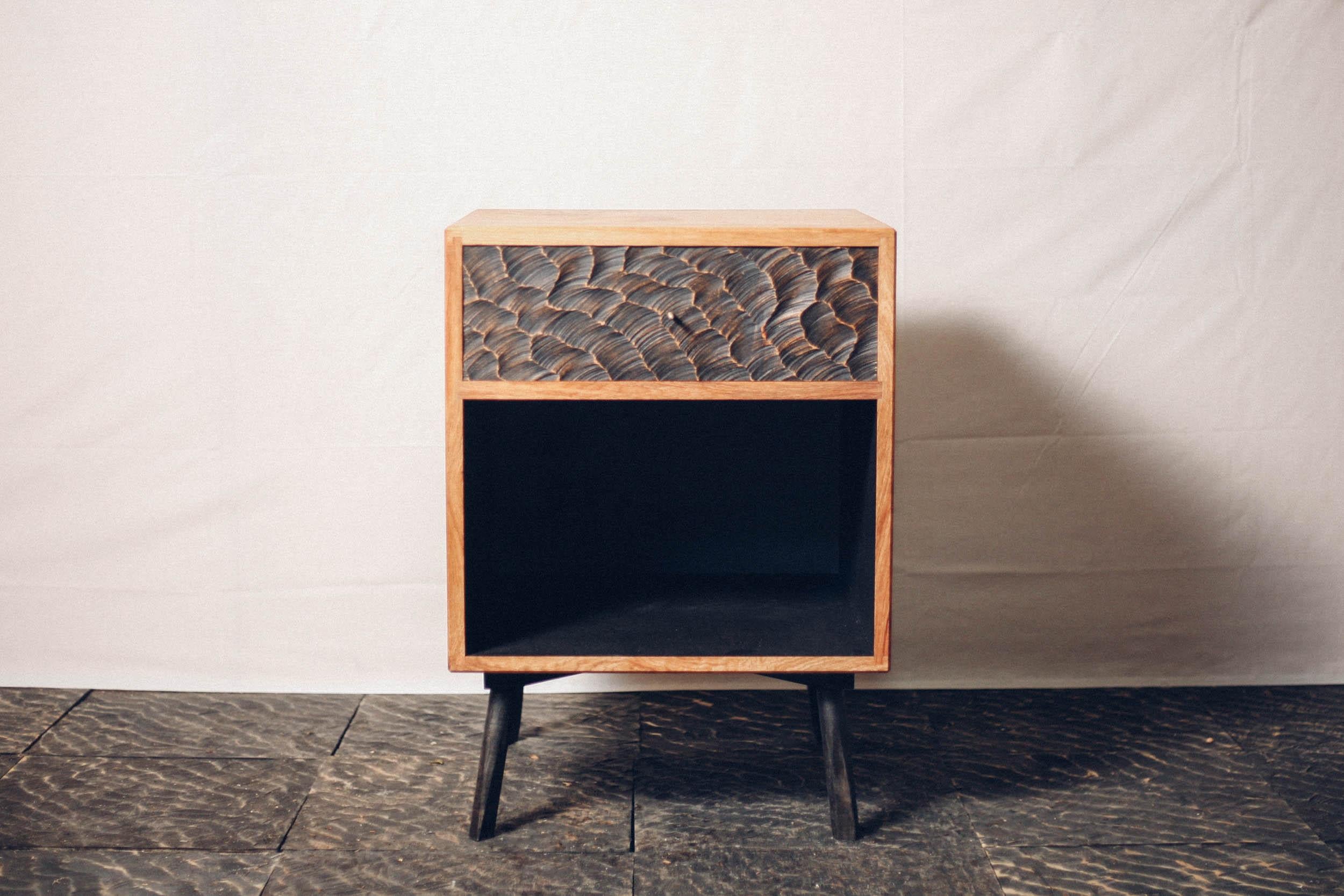 Choppy Waters Bedside Table by Temper Studio
Dimensions: D 40 x W 50 x H 65 cm.
Materials: Wood.

A sumptuous combination of carved wood, soft upholstery, and a brass plinth, the Choppy Waters Stool captures a sense of dark glamour and lends itself