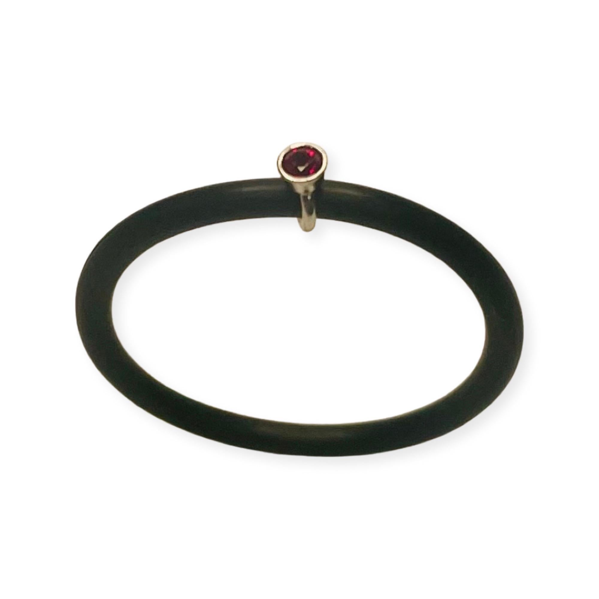 Chris Correia Platinum Ruby Rubber Ring. There is 1 natural ruby. The ruby is 2.0 mm and set in a 2.15 mm platinum bezel. The rubber shank is 1.5 mm wide.  It is finger size 7 but we can size it for an additional fee. 
100-60-174
