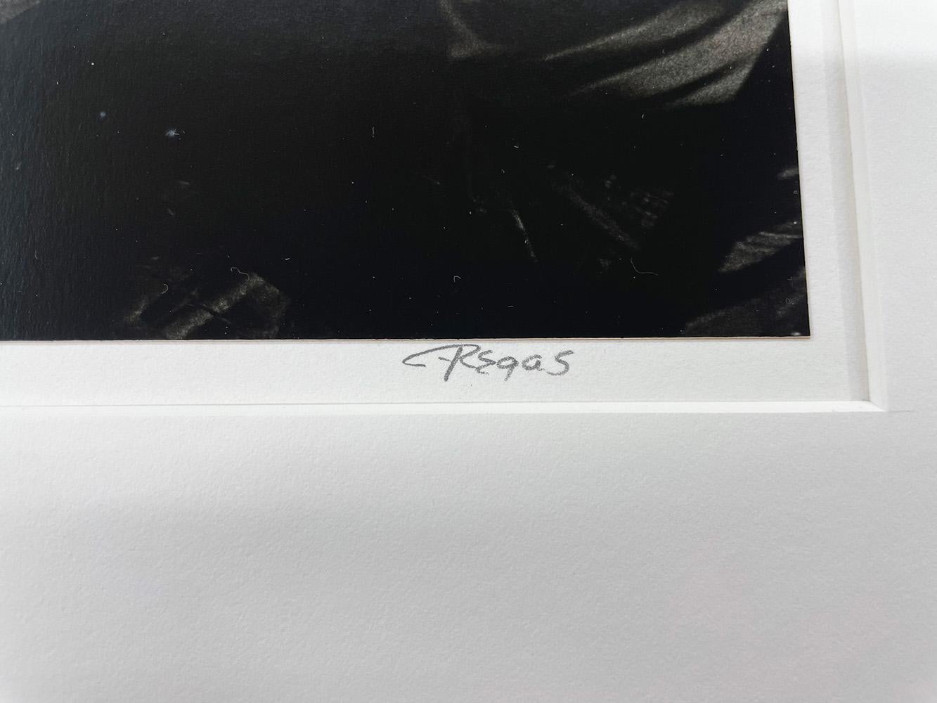 Domino Players, Lawn, TX de Chris Regas es una impresión en blanco y negro de gelatina de plata de cuatro vaqueros sentados a una mesa, jugando al dominó. 

Impresión en plata gelatina
8.5 x 11.5 in.
Firmado a lápiz en el margen de la
