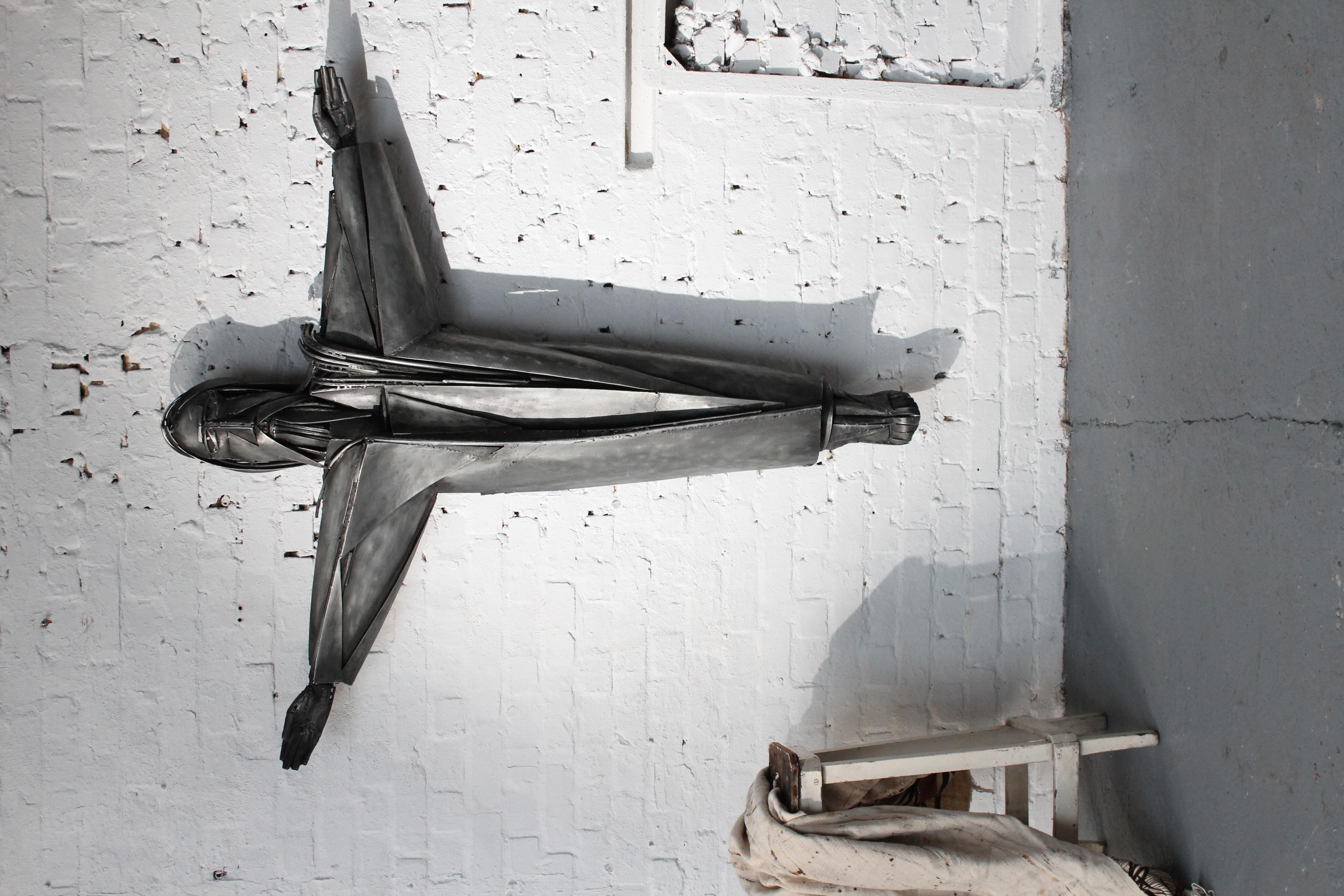 Christ (height 160 cm) by the Belgian sculptor Roger Bonduel (1930-2019) in welded and patinated steel. From 1961 to 1966, Roger Bonduel taught visual art at the Academy of Fine Arts in Bruges. Bonduel became best known for its sculptures,